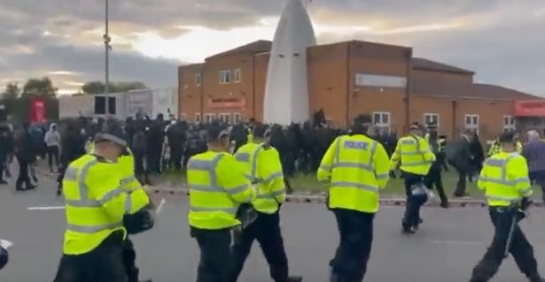 Officers approach the protesters as a huge crowd gathers