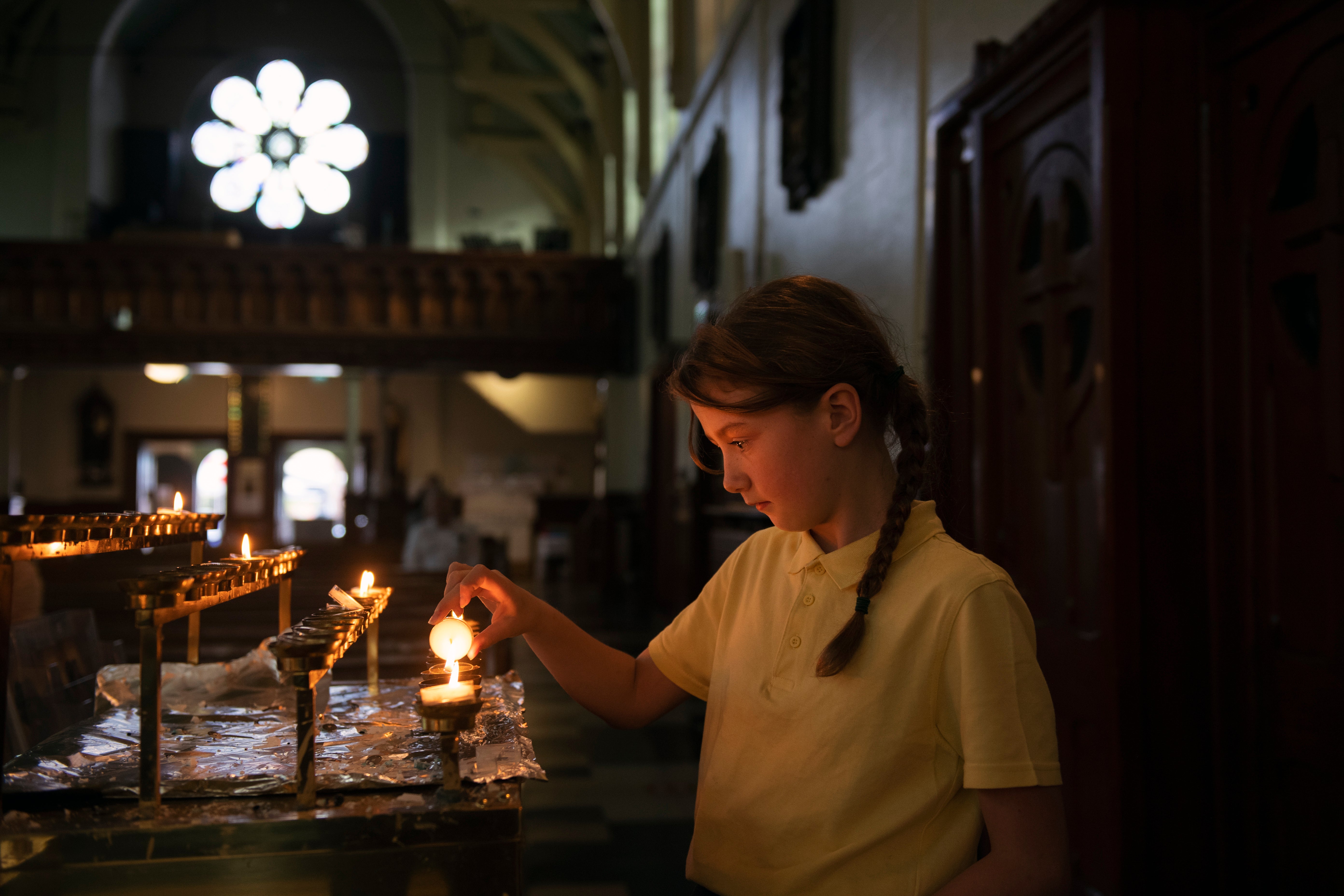 Caoilte McIlKenny, 9, lights a candle at St Mary’s Church in Belfast on Thursday