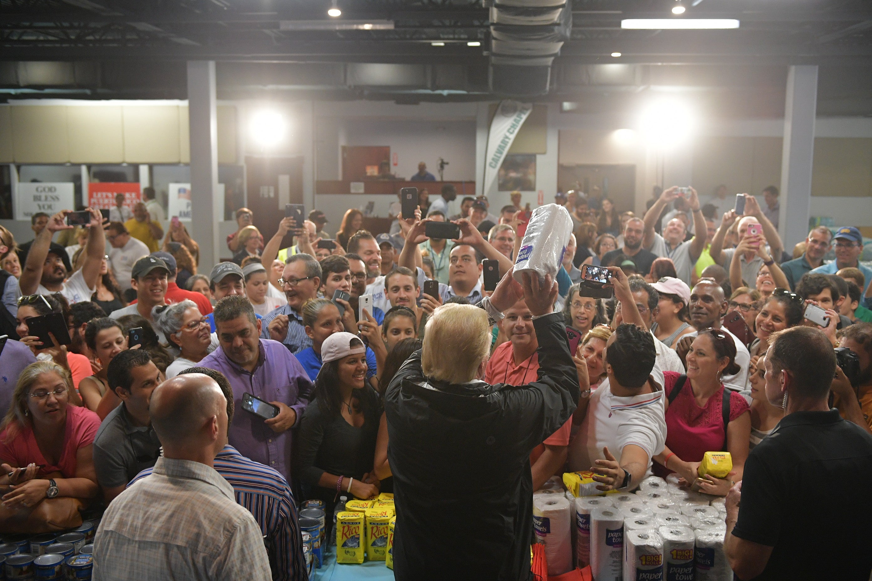 US President Donald Trump throws a paper towel roll as he visits the Cavalry Chapel in Guaynabo, Puerto Rico on October 3, 2017