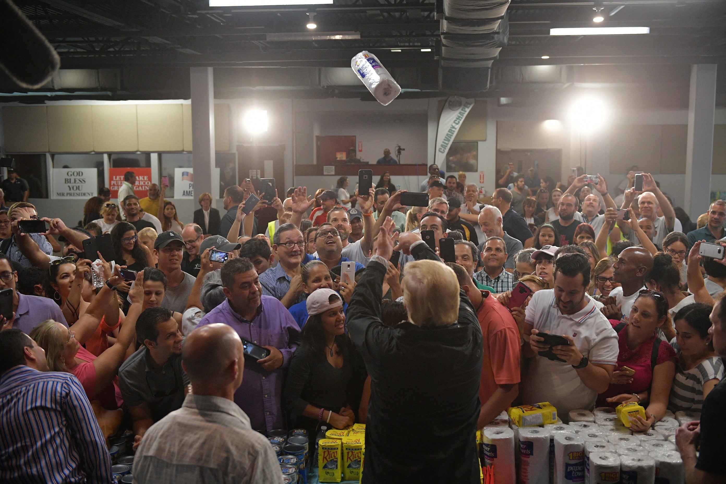 US President Donald Trump throws a paper towel roll as he visits the Cavalry Chapel in Guaynabo, Puerto Rico on October 3, 2017