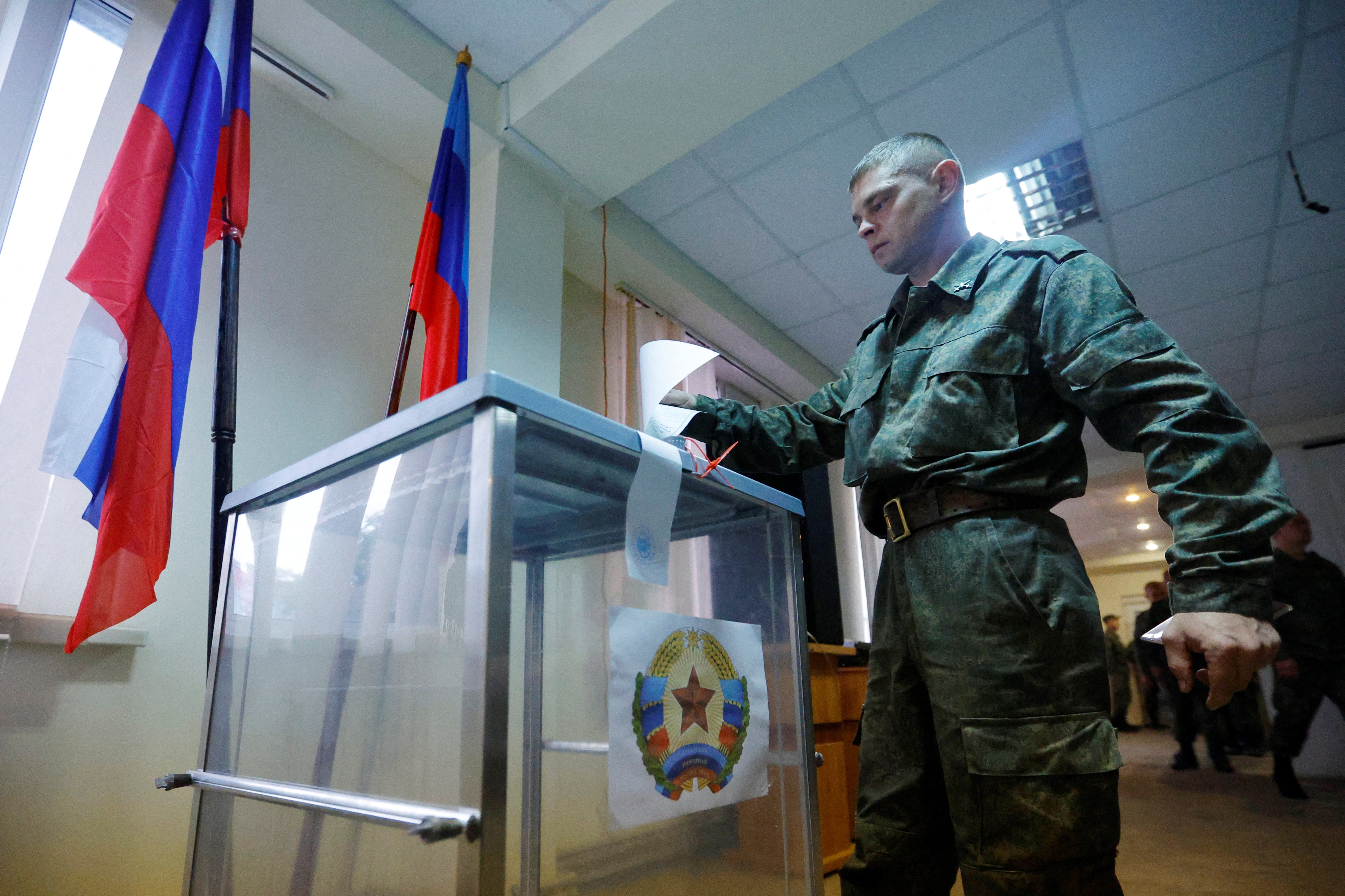 A service member of the self-proclaimed Luhansk People's Republic (LPR) votes during a referendum on joining LPR to Russia