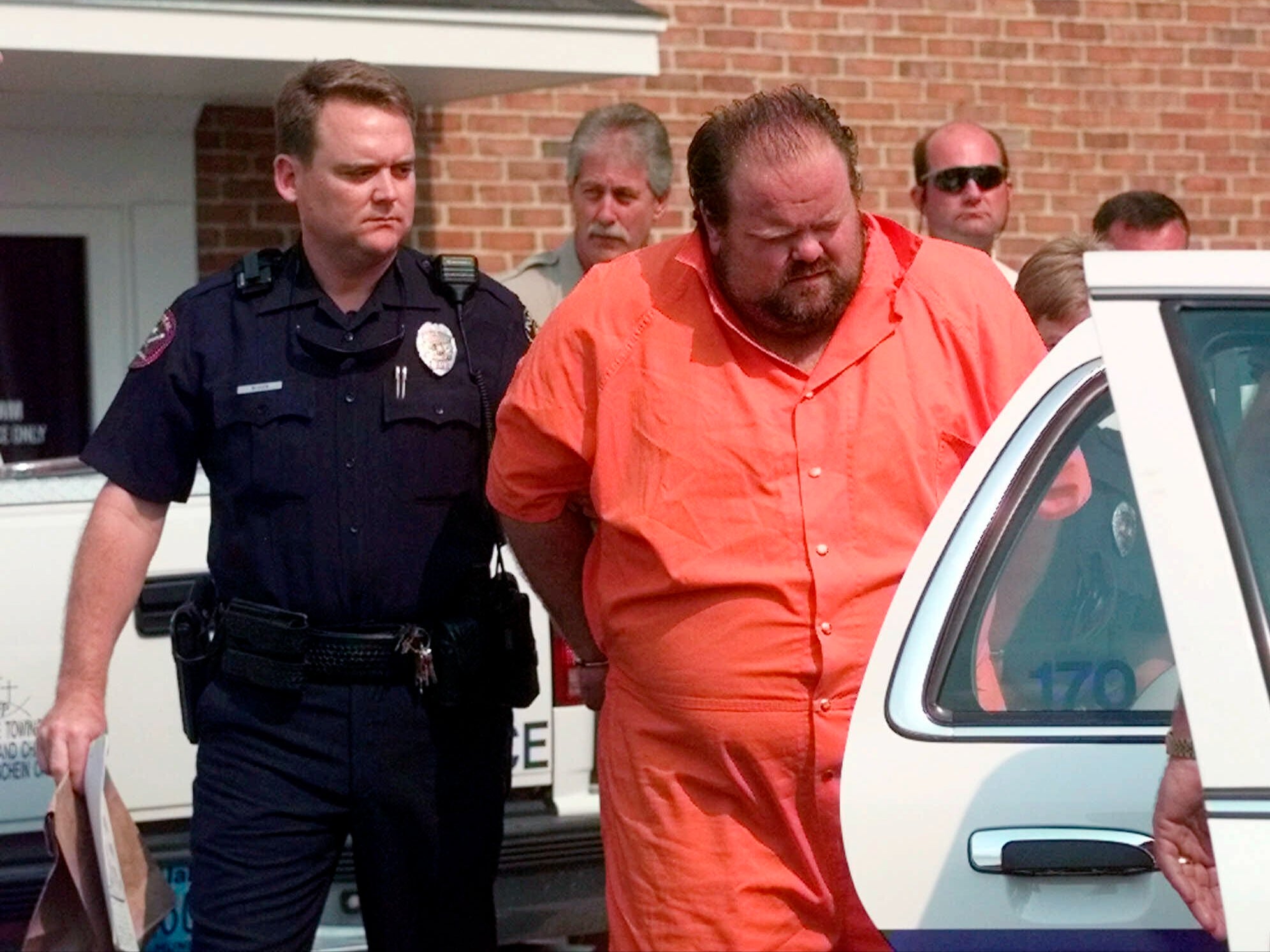 Officials escort murder suspect Alan Eugene Miller away from the Pelham City Jail in Ala., on Aug. 5, 1999