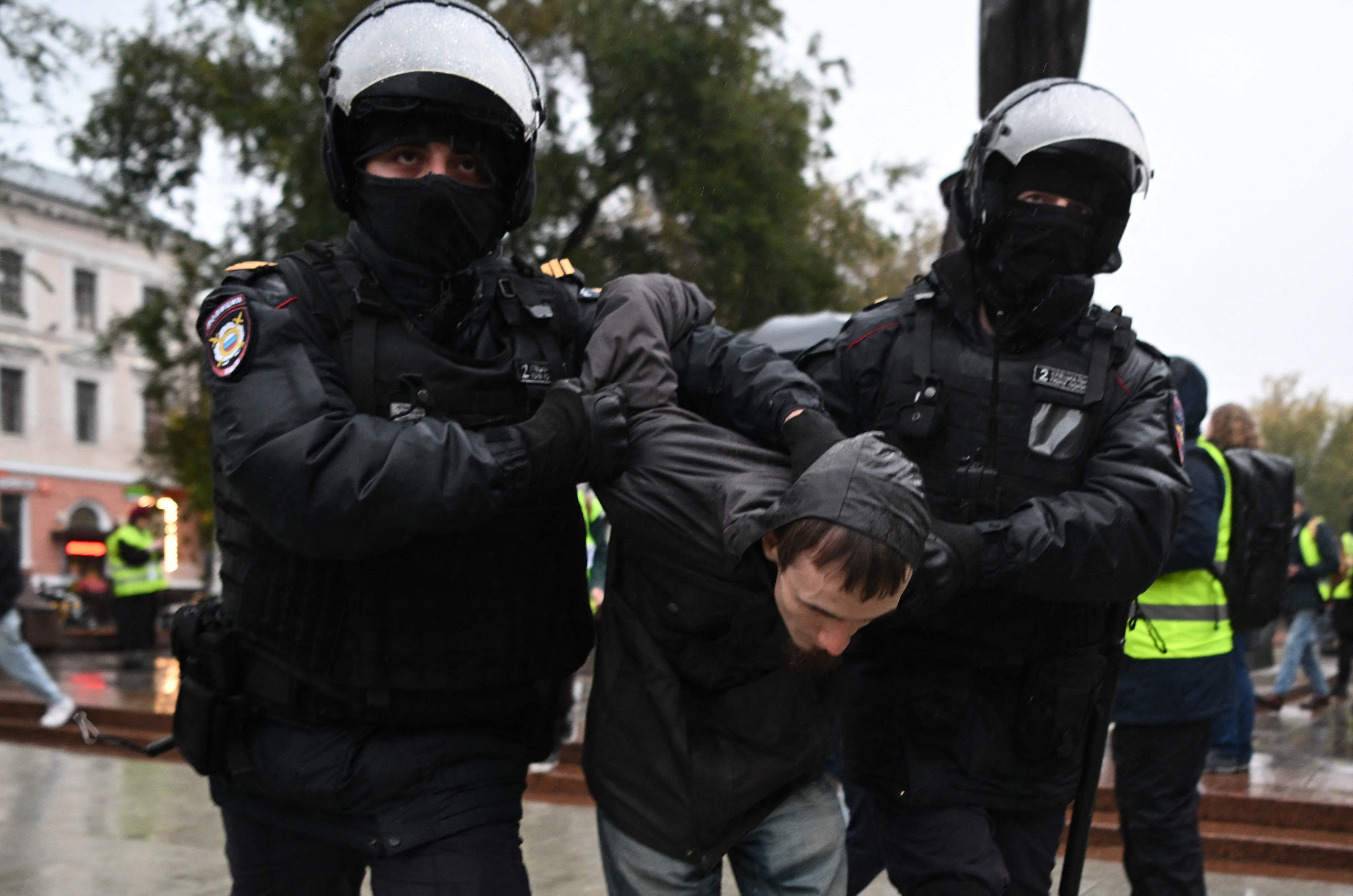 Police detain a young man involved in anti-conscription protest