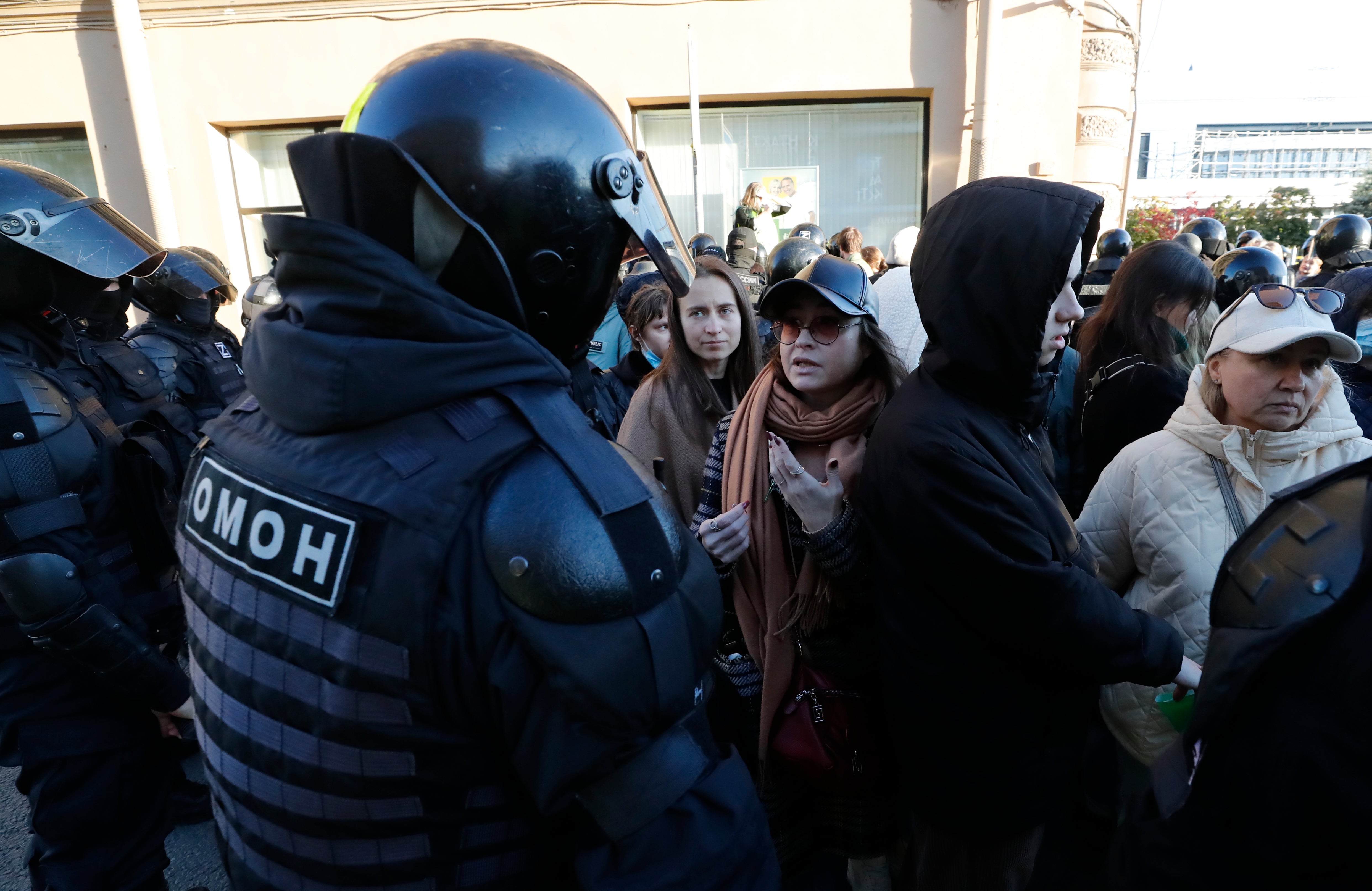 Russian police officers talk with people taking part in a protest against Russia’s partial military mobilisation due to the conflict in Ukraine, in downtown St Petersburg