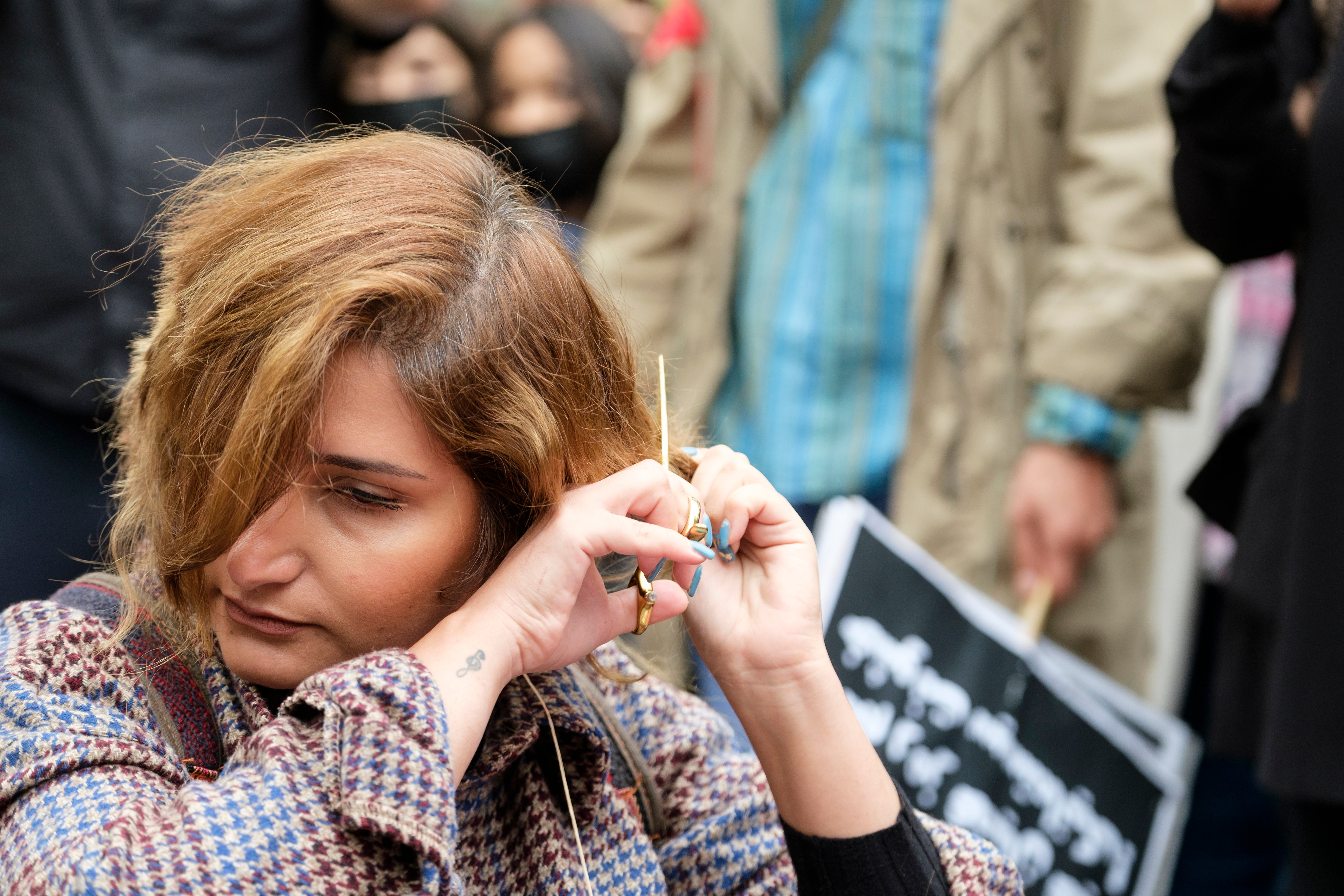 A woman cuts her hairs as a sign of protest in Brussels