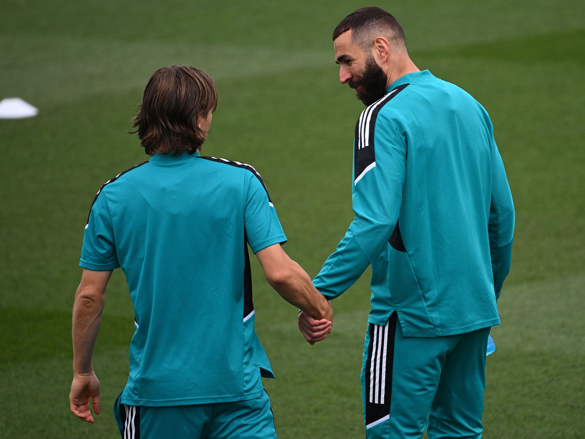 Real Madrid’s French forward Karim Benzema and the Croatian midfielder Luka Modric hold hands during a training session in May