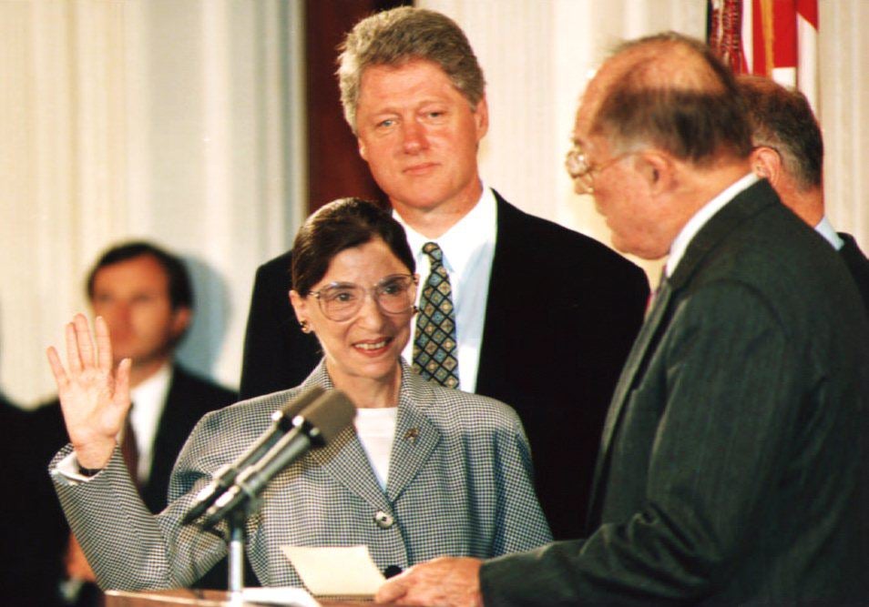 Chief Justice William Rehnquist administers the oath of office to Ruth Bader Ginsburg as president Bill Clinton looks on in August 1993