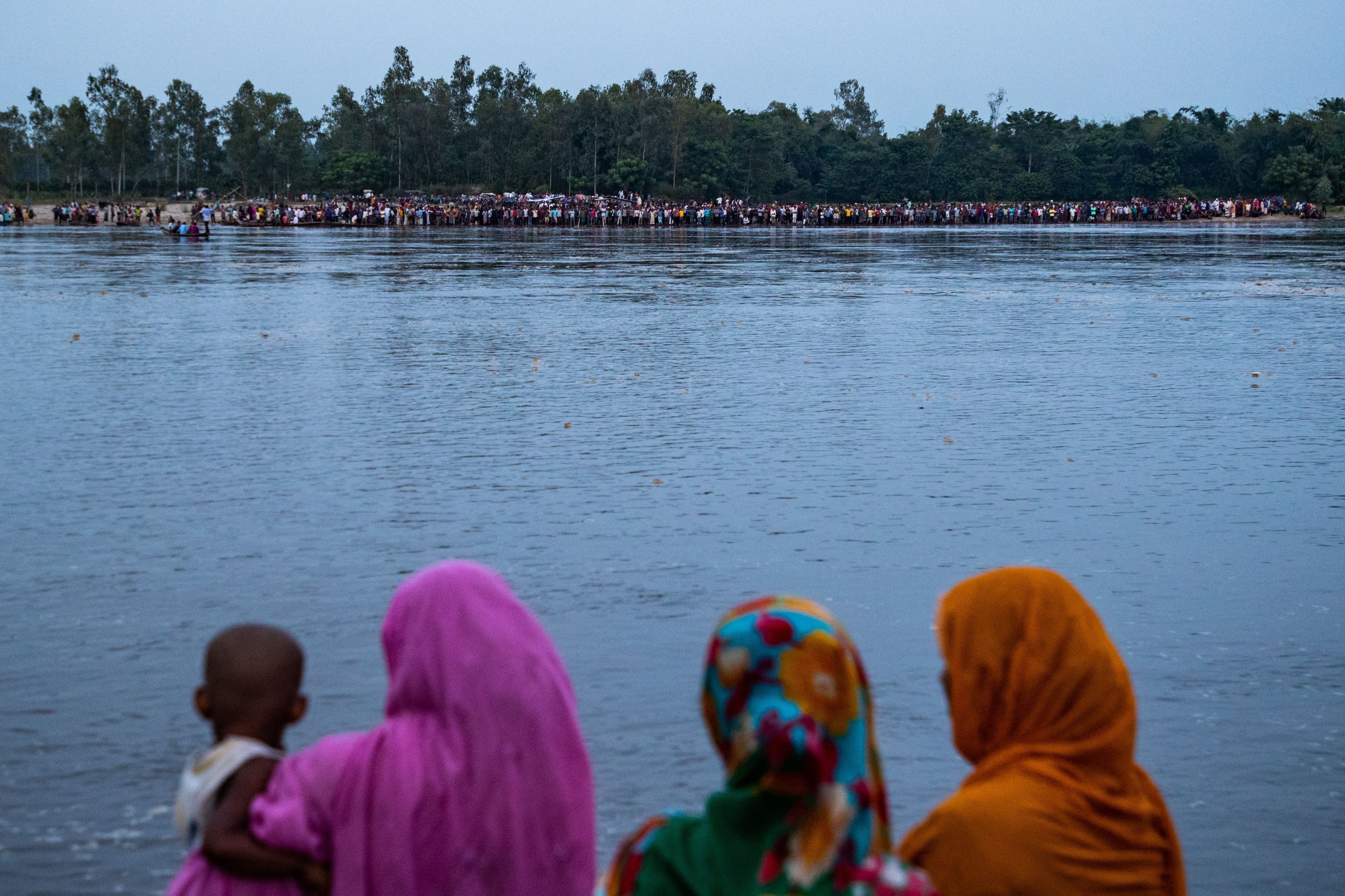 In this picture taken on 25 September 2022, people gather along the banks of the Karatoa river after a boat capsized near the town of Boda