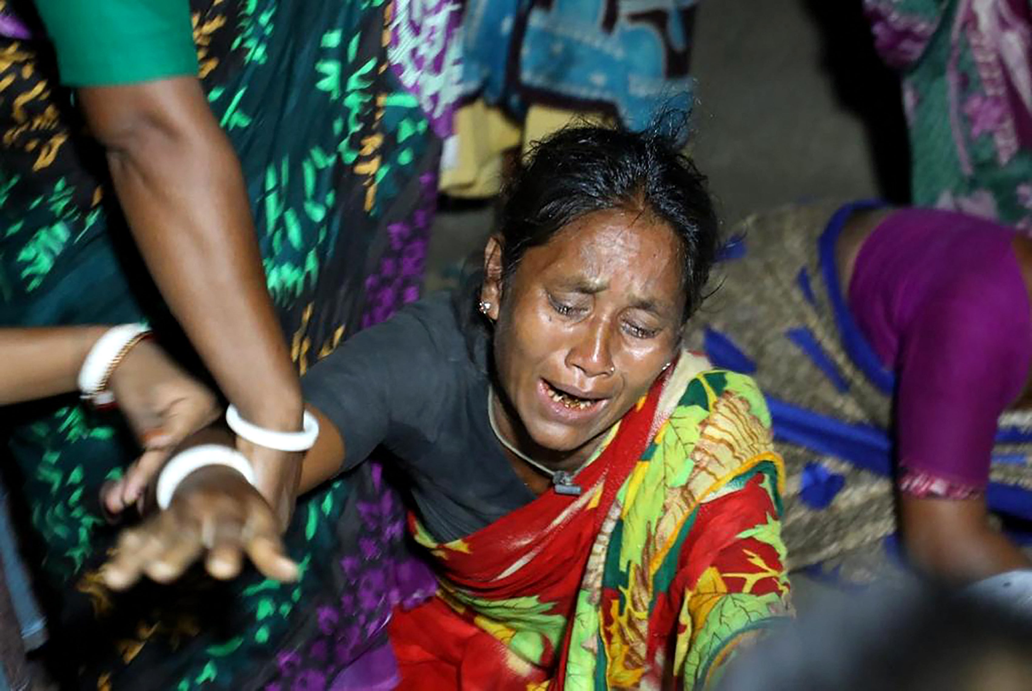 A relative of a victim who died after a boat capsized in river Karotoa, weeps near Boda town on 26 September 2022