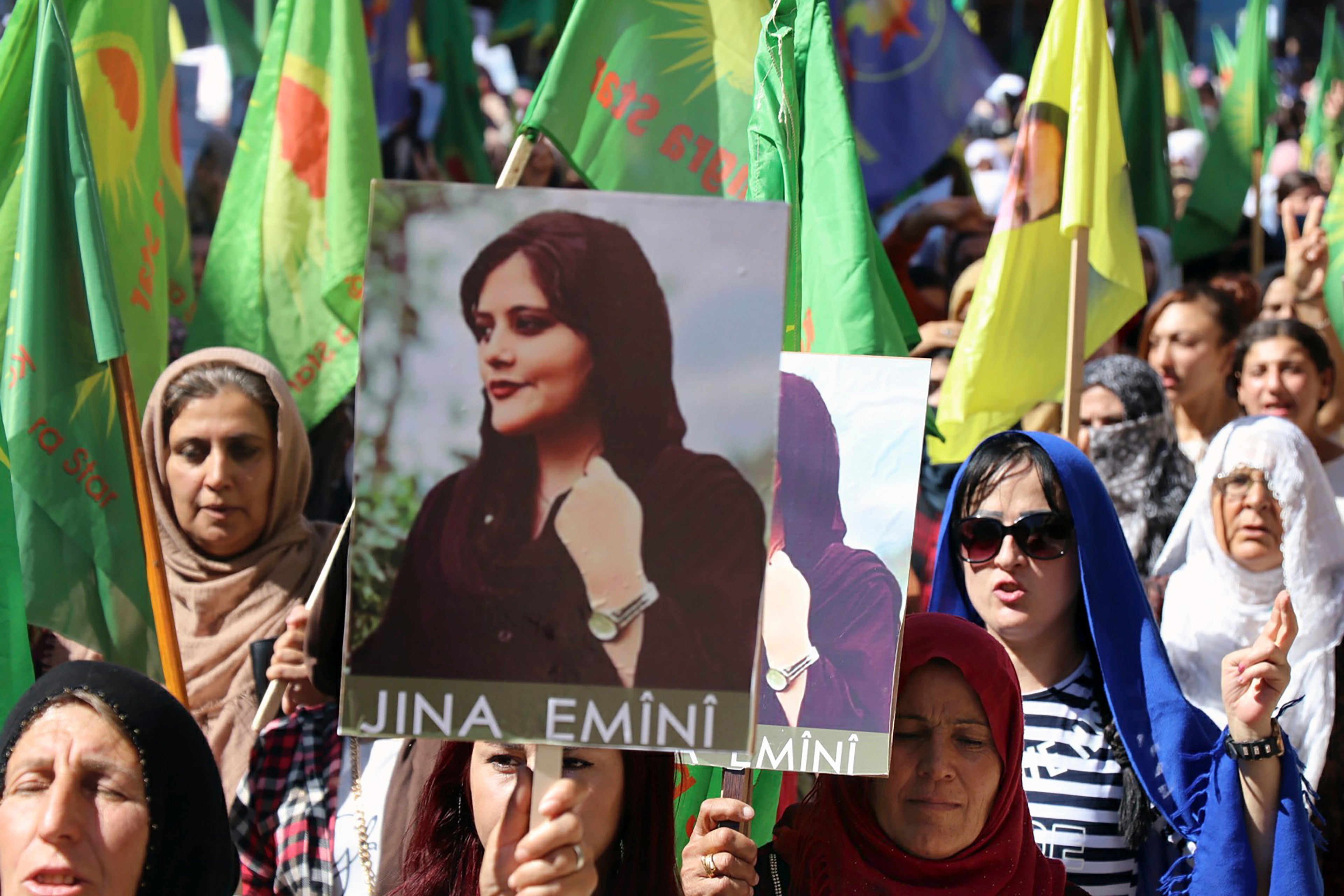 Kurdish women hold portraits of Mahsa Amini during a protest in Qamishli, northern Syria