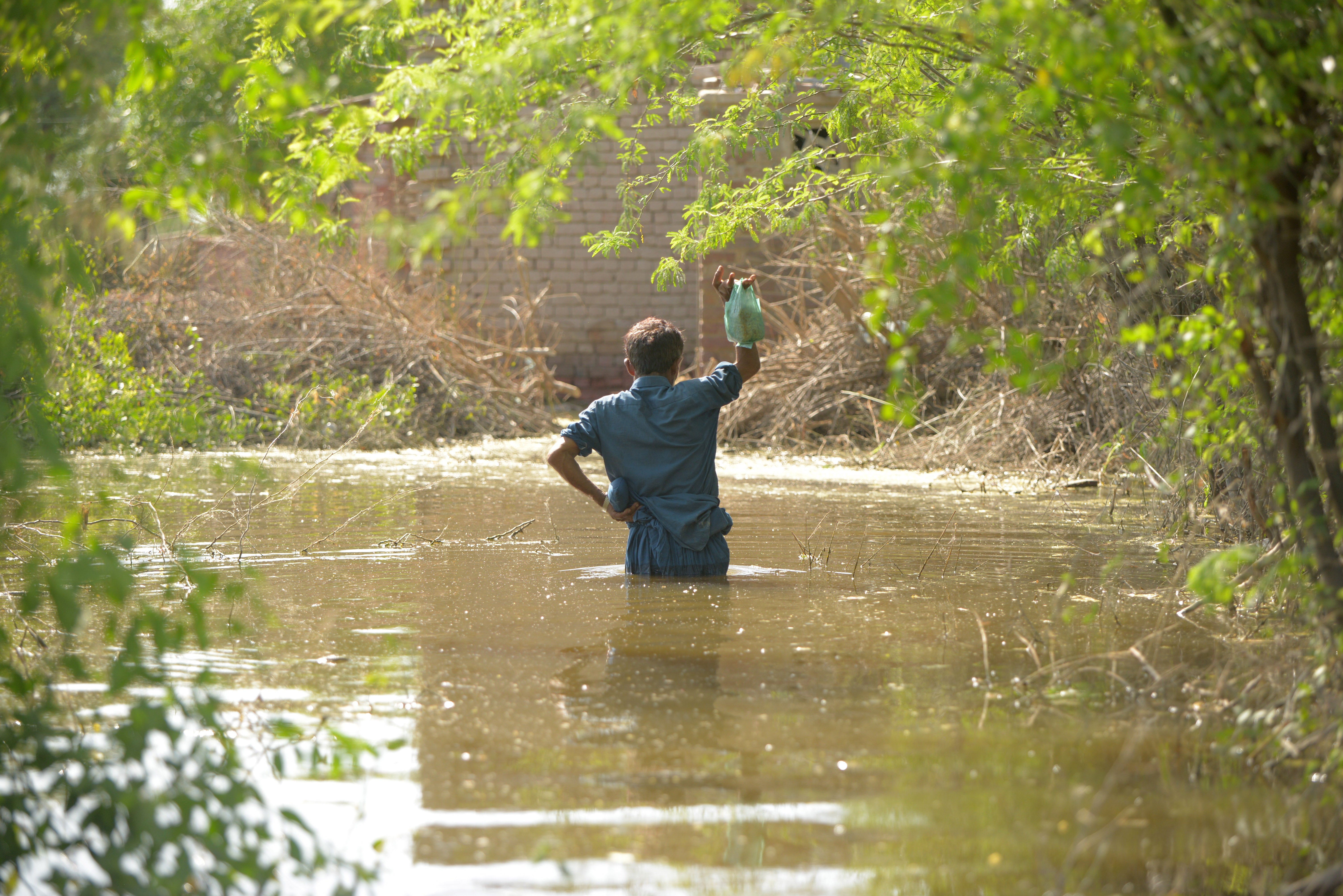 A man wades through floodwater in Mitiyari Hyderabad