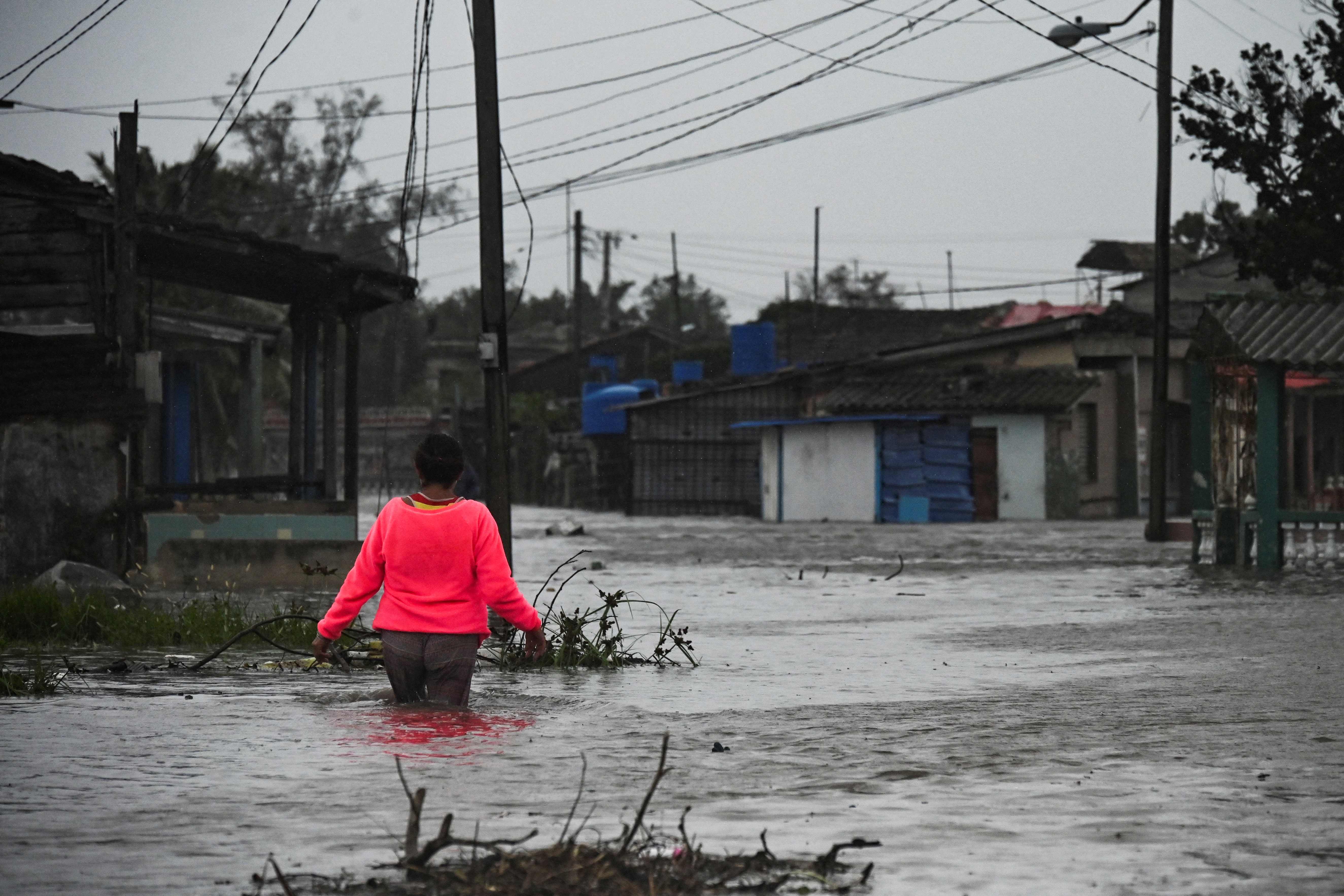 A woman walks through a flooded street in Batabano, Cuba, on Tuesday, during the passage of hurricane Ian.