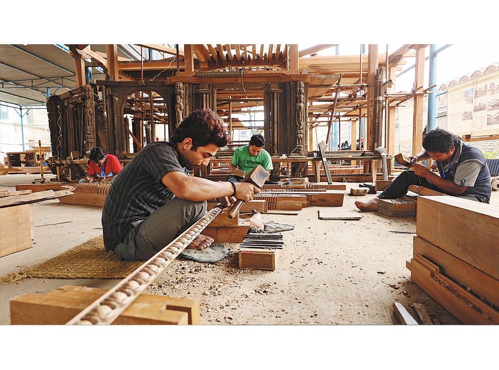 Nepali artisans from the Chinese team repair wooden doors and windows