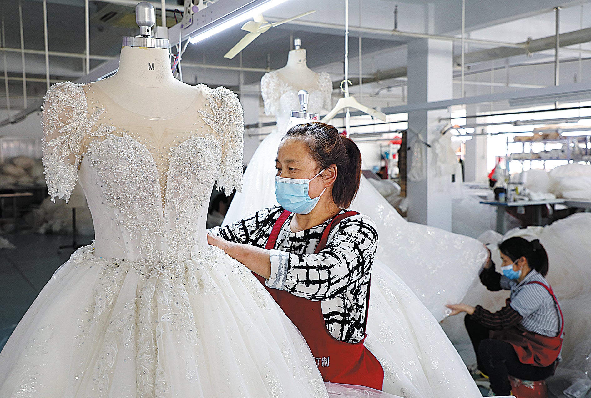 Employees make wedding dresses at a factory workshop in Lu’an, Anhui province.