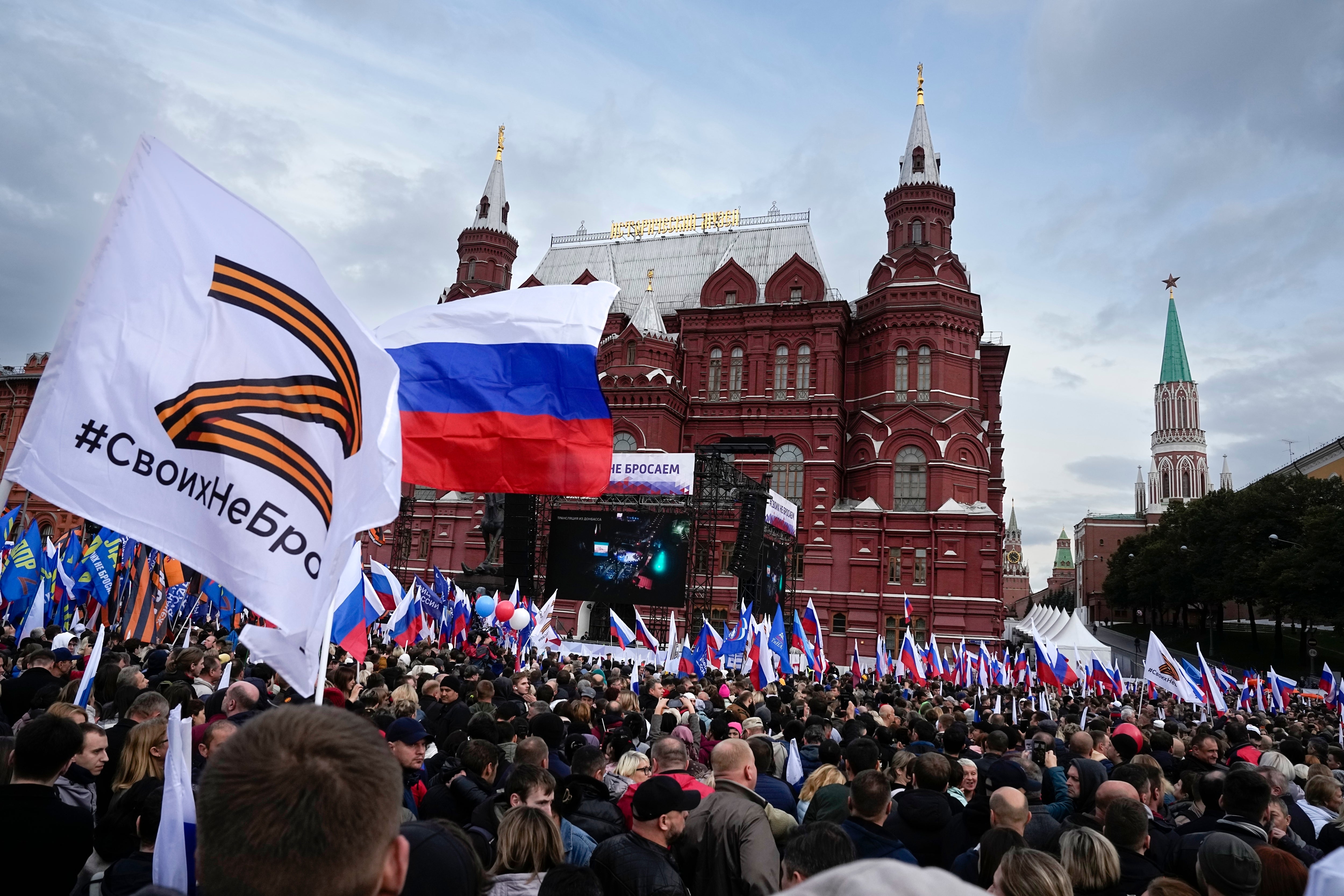 Demonstrators hold Russian state flags and some with the letter Z in Moscow on Friday