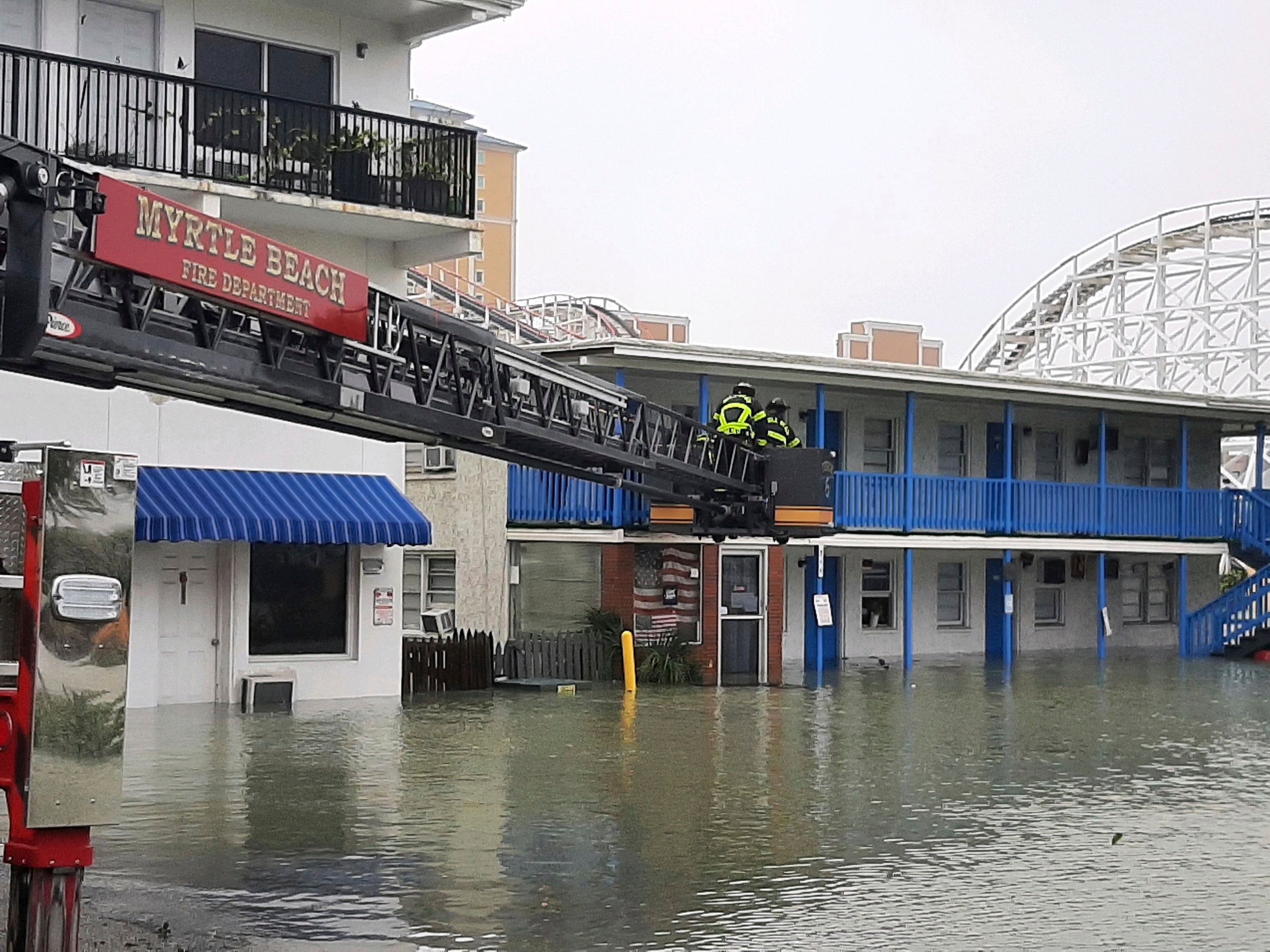 The Myrtle Beach Fire Department rescues people from the second floor of a building as flood from Hurricane Ian overtake the city on Friday