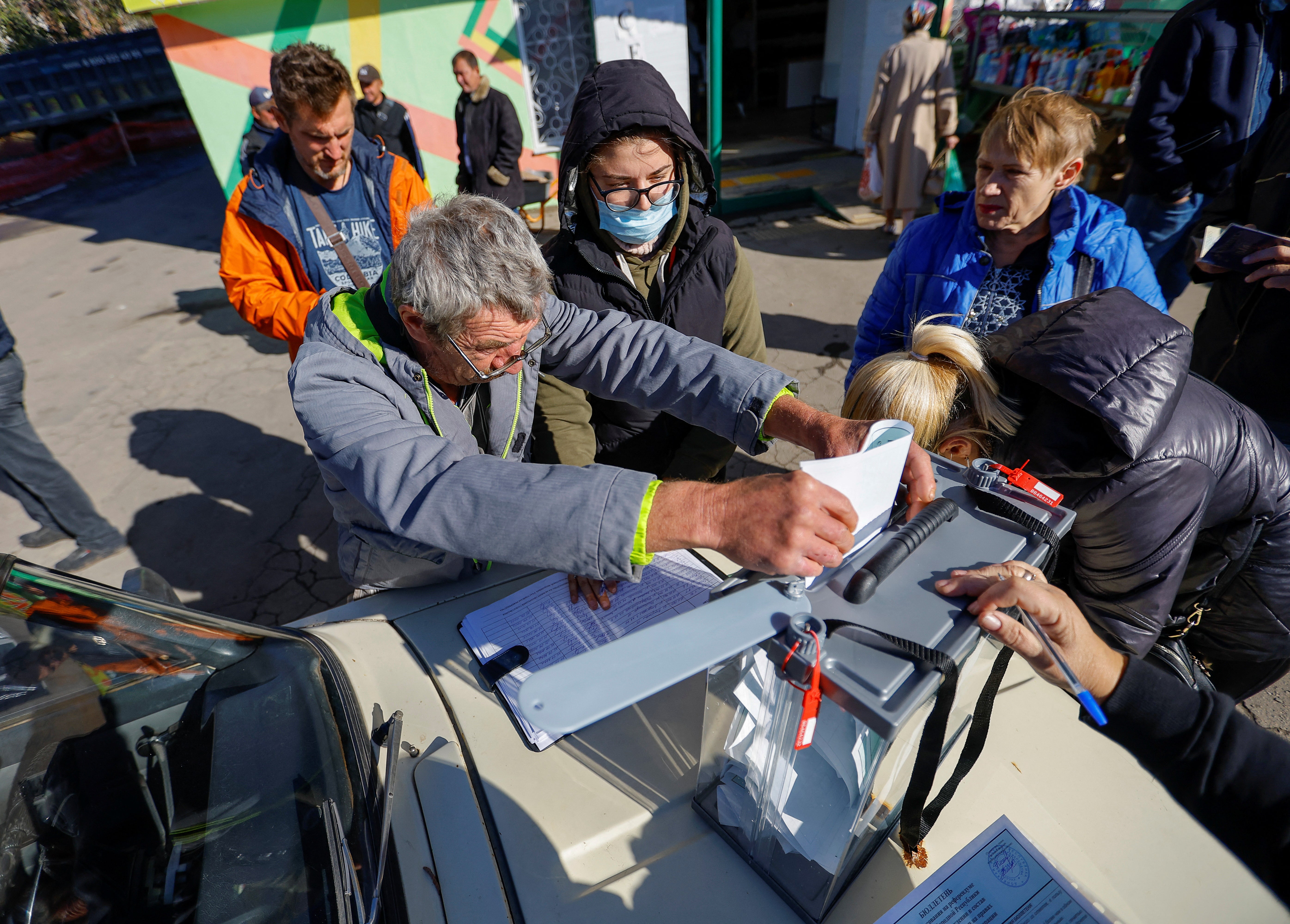 A local resident casts his vote into a mobile ballot box on the third day of a referendum on the joining of Donetsk to Russia