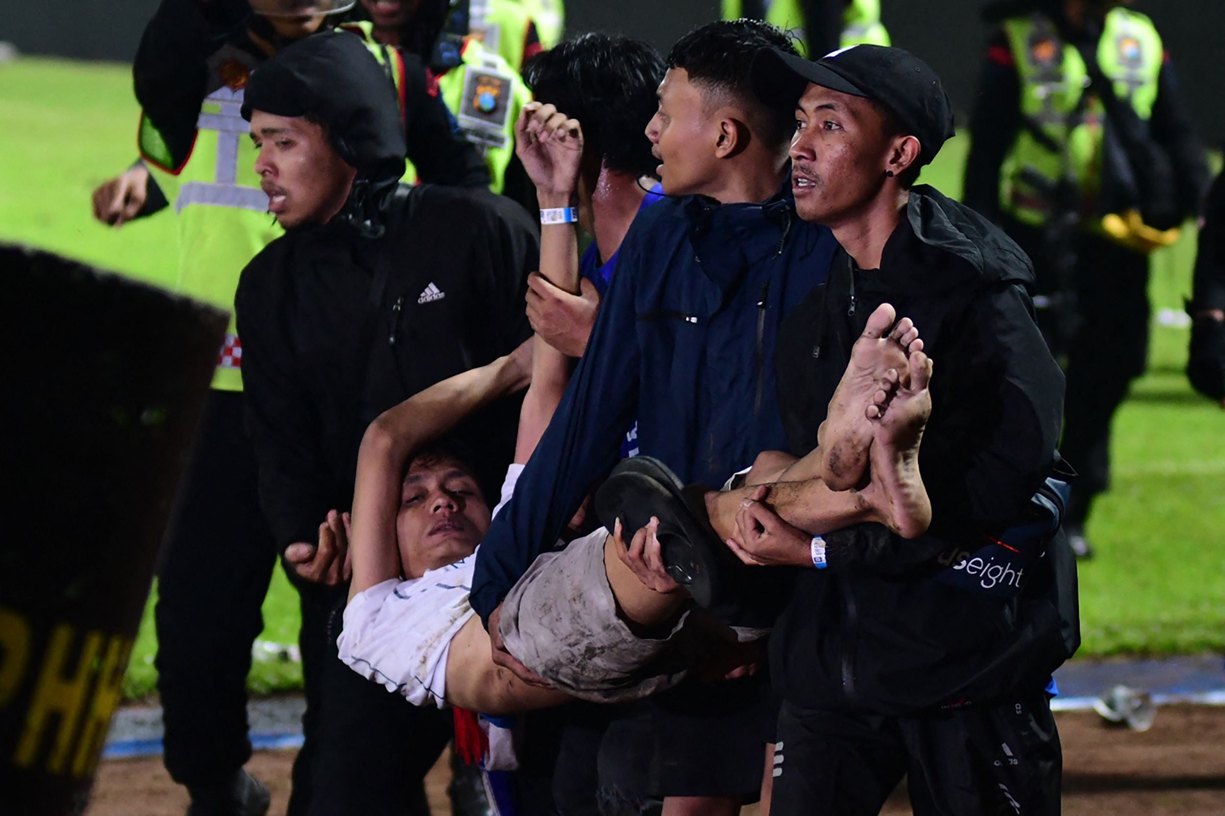 A group of football fans carry an unconscious man