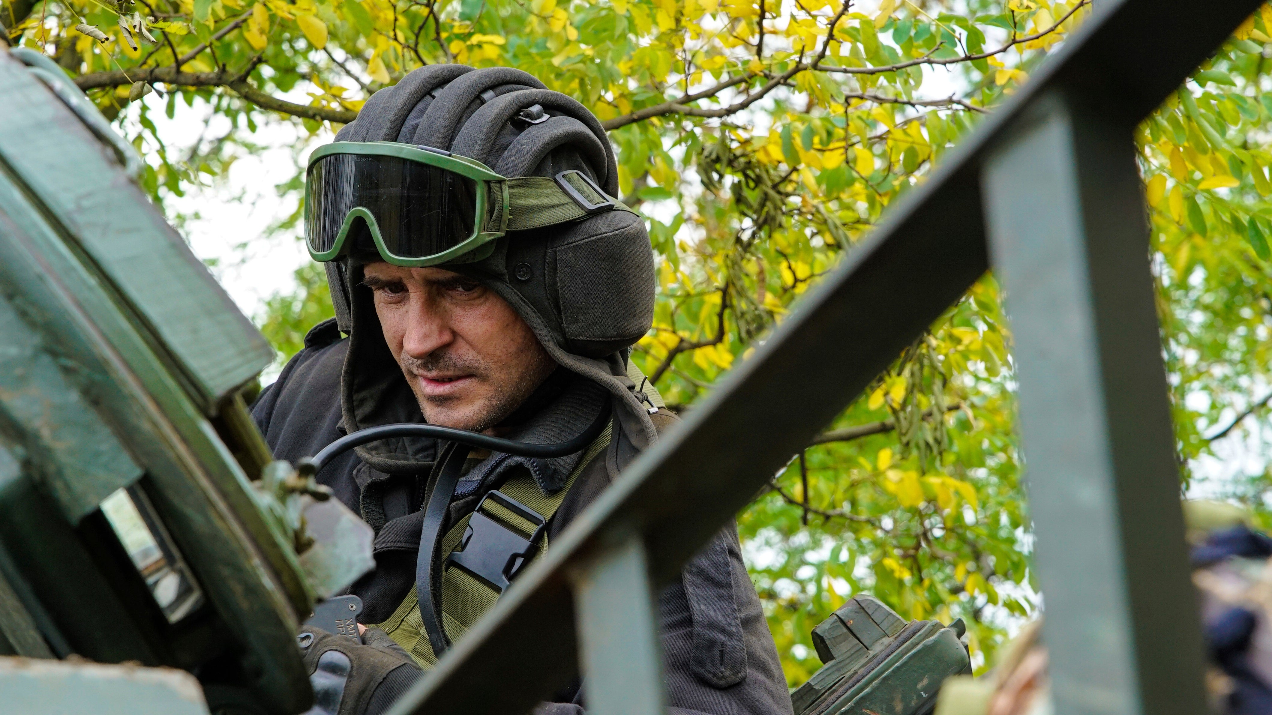 A Ukrainian serviceman sits on a T-80 tank that they claimed had been captured from the Russian army, in Bakhmut, Ukraine