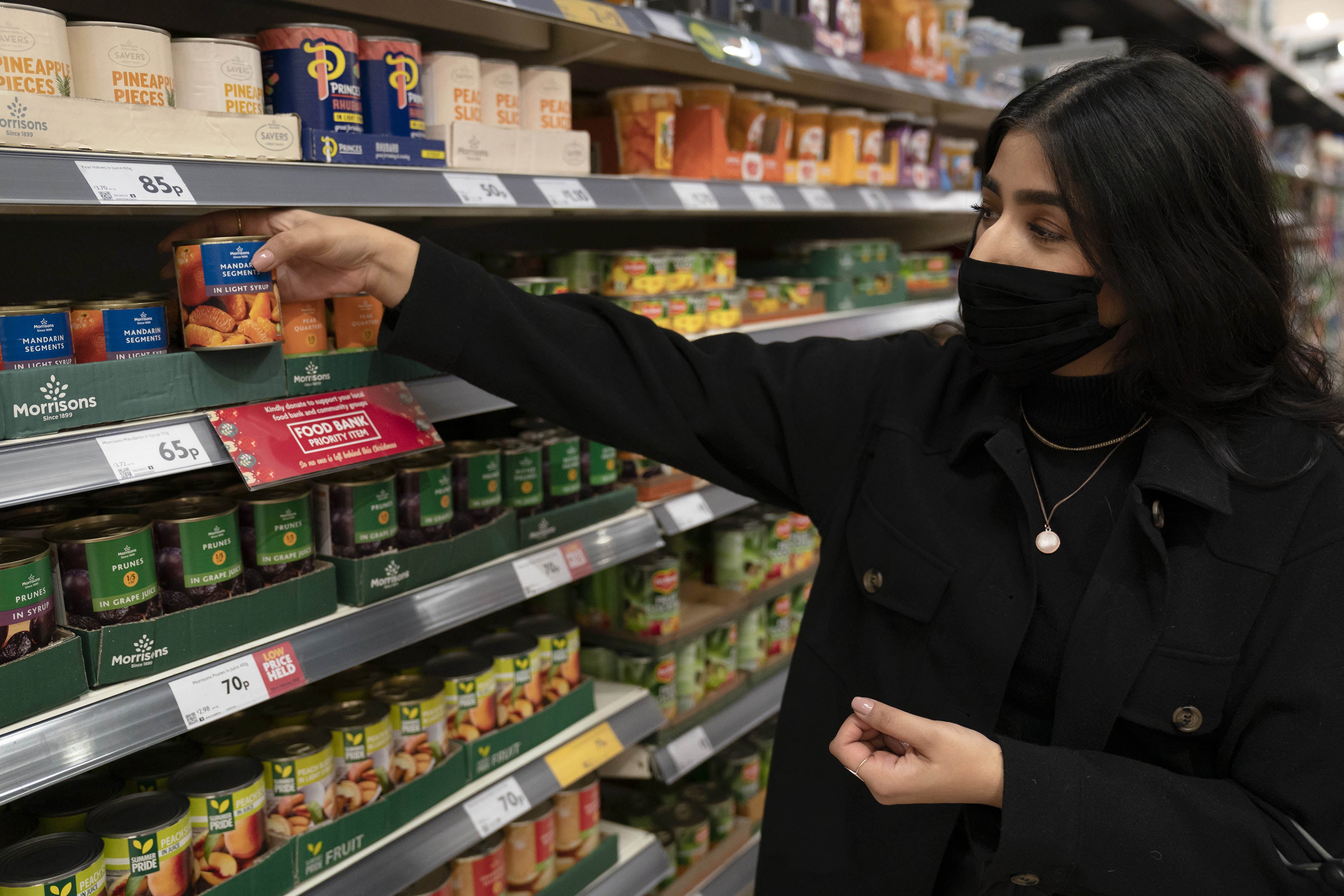 Sameera Yasmeen picks a Food Bank Priority Item from the shelf at Morrisons in Bradford