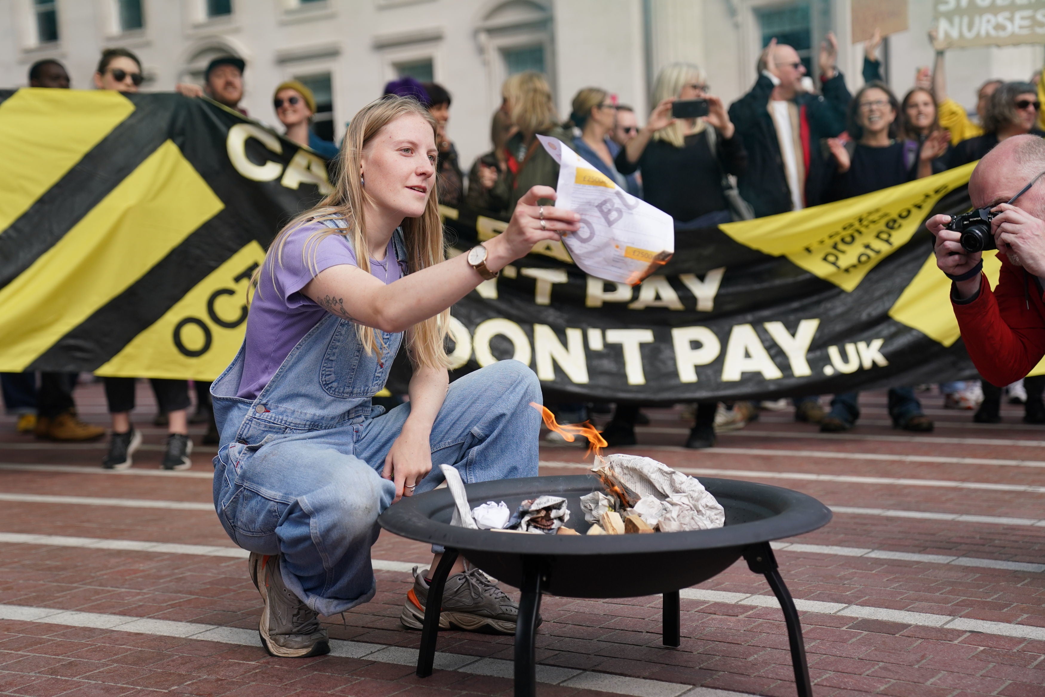 A protester takes part in a 'energy bill burning' in Birmingham to protest against rising energy bills and the cost of living crisis