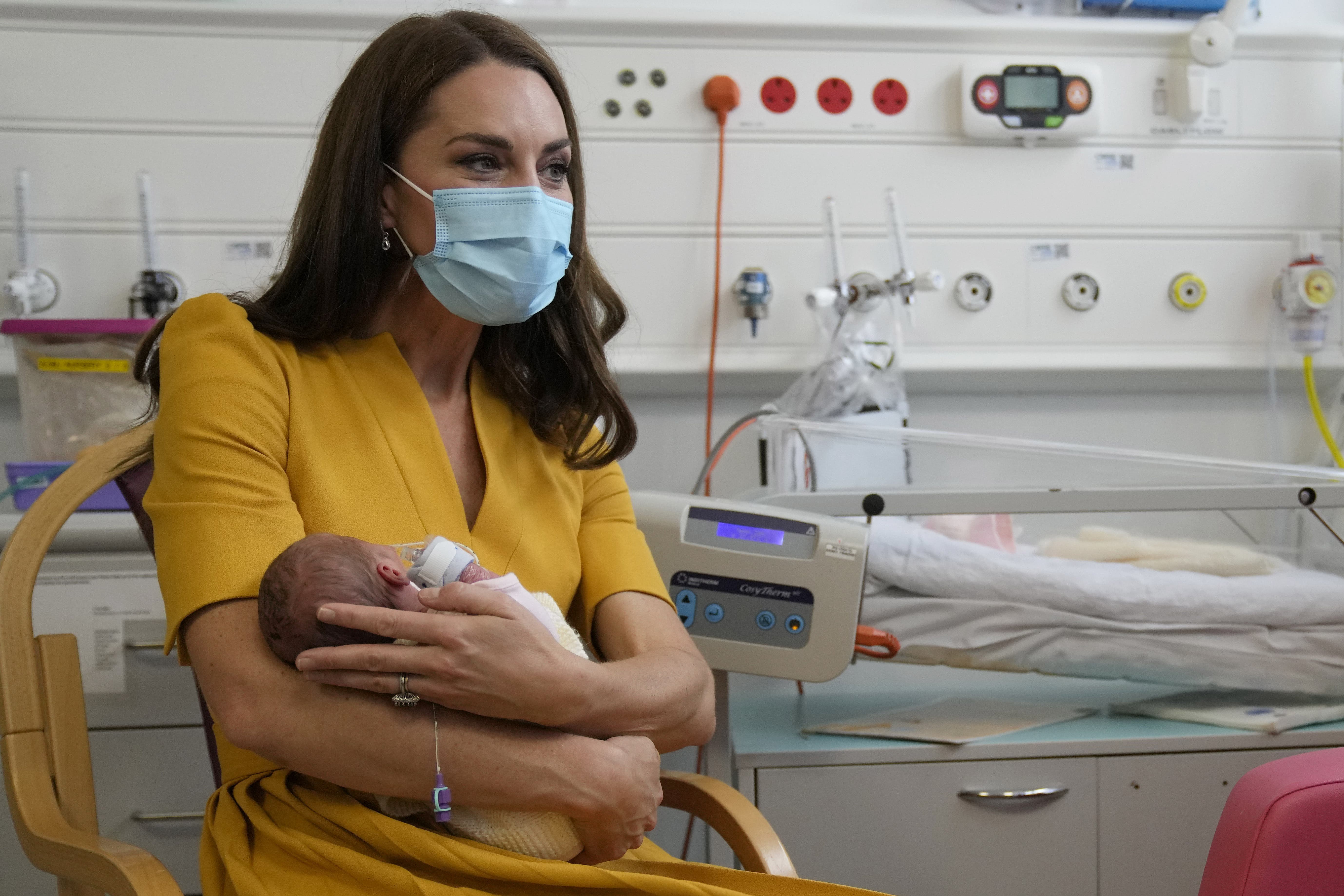 The Princess of Wales speaks to Sylvia Novak as she cradles Ms Novak’s daughter Bianca during a visit to the Royal Surrey County Hospital’s maternity unit in Guildford (Alistair Grant/PA)