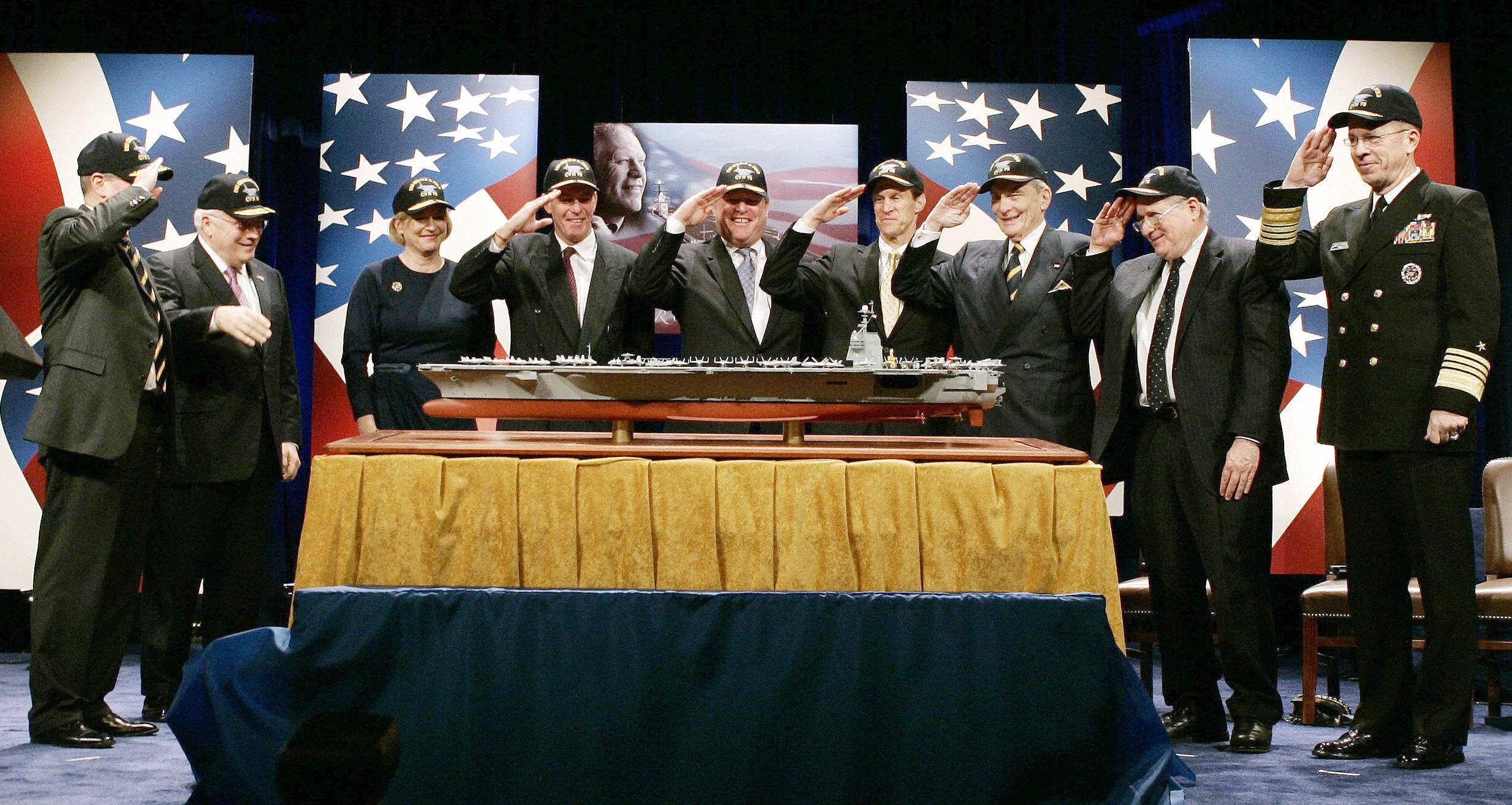 Government officials and family members of former US President Gerald Ford salute a model of a new aircraft carrier named the USS Gerald R. Ford during a naming ceremony at the Pentagon in Washington, 16 January 2007