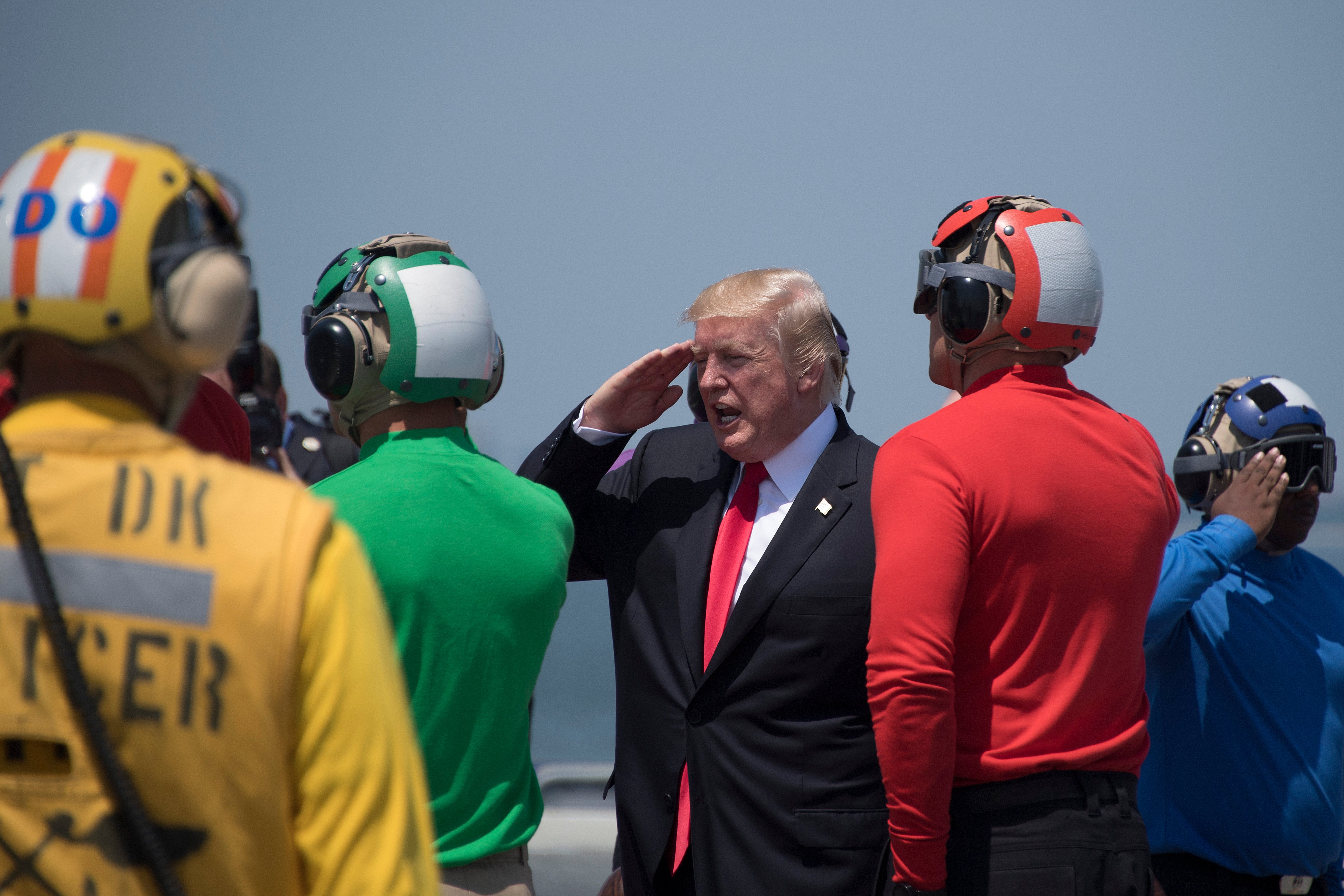 Donald Trump (3rd R) salutes as he departs the USS Gerald R. Ford in Norfolk, Virginia, on July 22, 2017