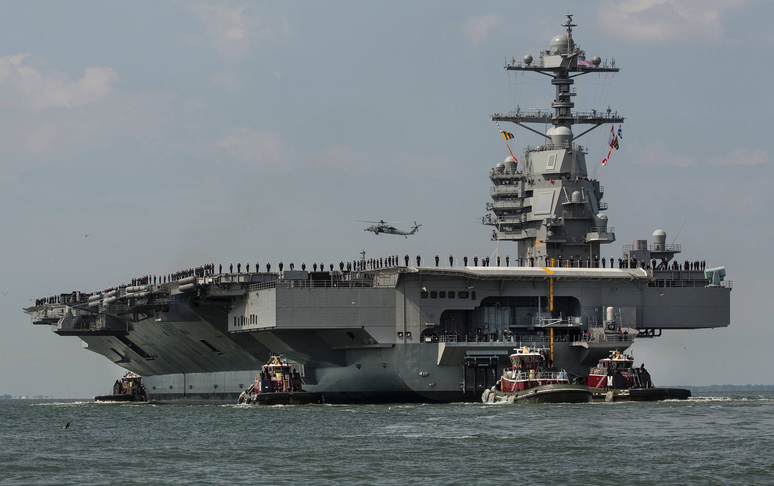 In this April 14, 2017 file photo, as crew members stand on the deck, the aircraft carrier USS Gerald R. Ford heads to the Norfolk, Va., naval station