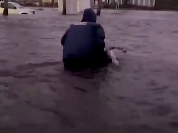 Johnny Lauder wheels his disabled mother through flood waters after Hurricane Ian struck Naples, Florida