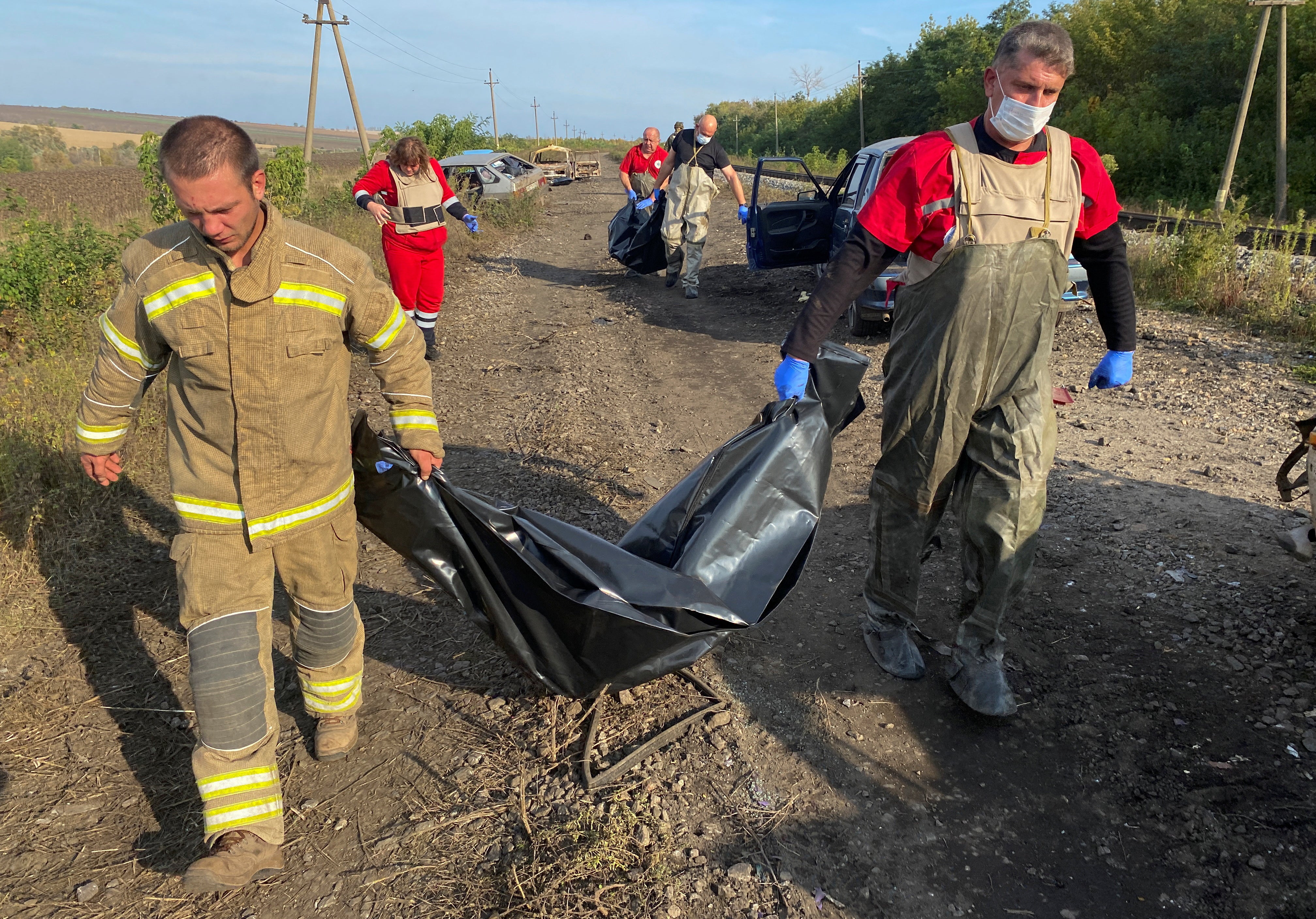 Volunteers remove bodies from the deadly attack on an evacuee convoy in Kurylivka