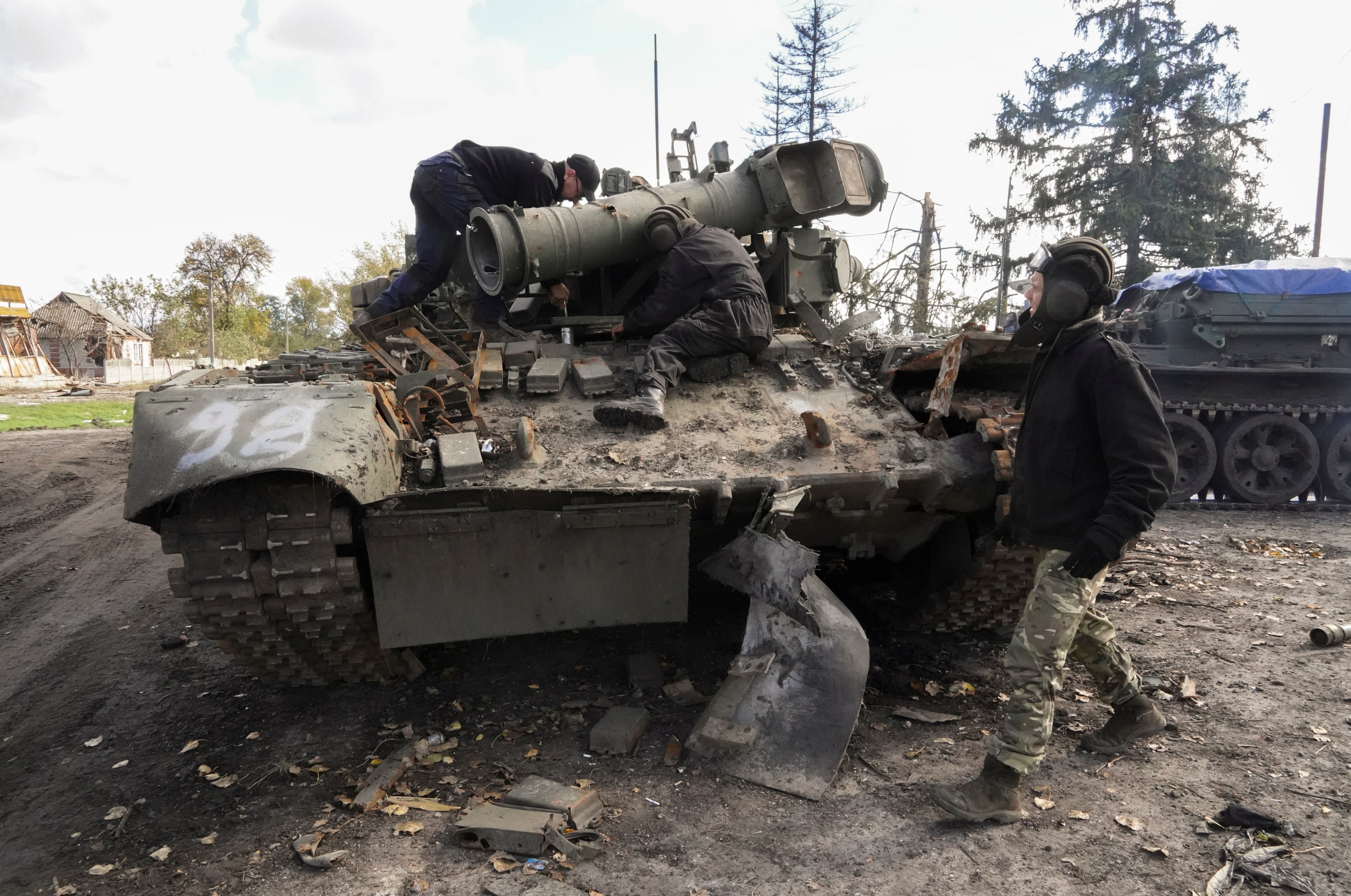 Ukrainian soldiers prepare to tow a captured Russian tank near Kupyansk