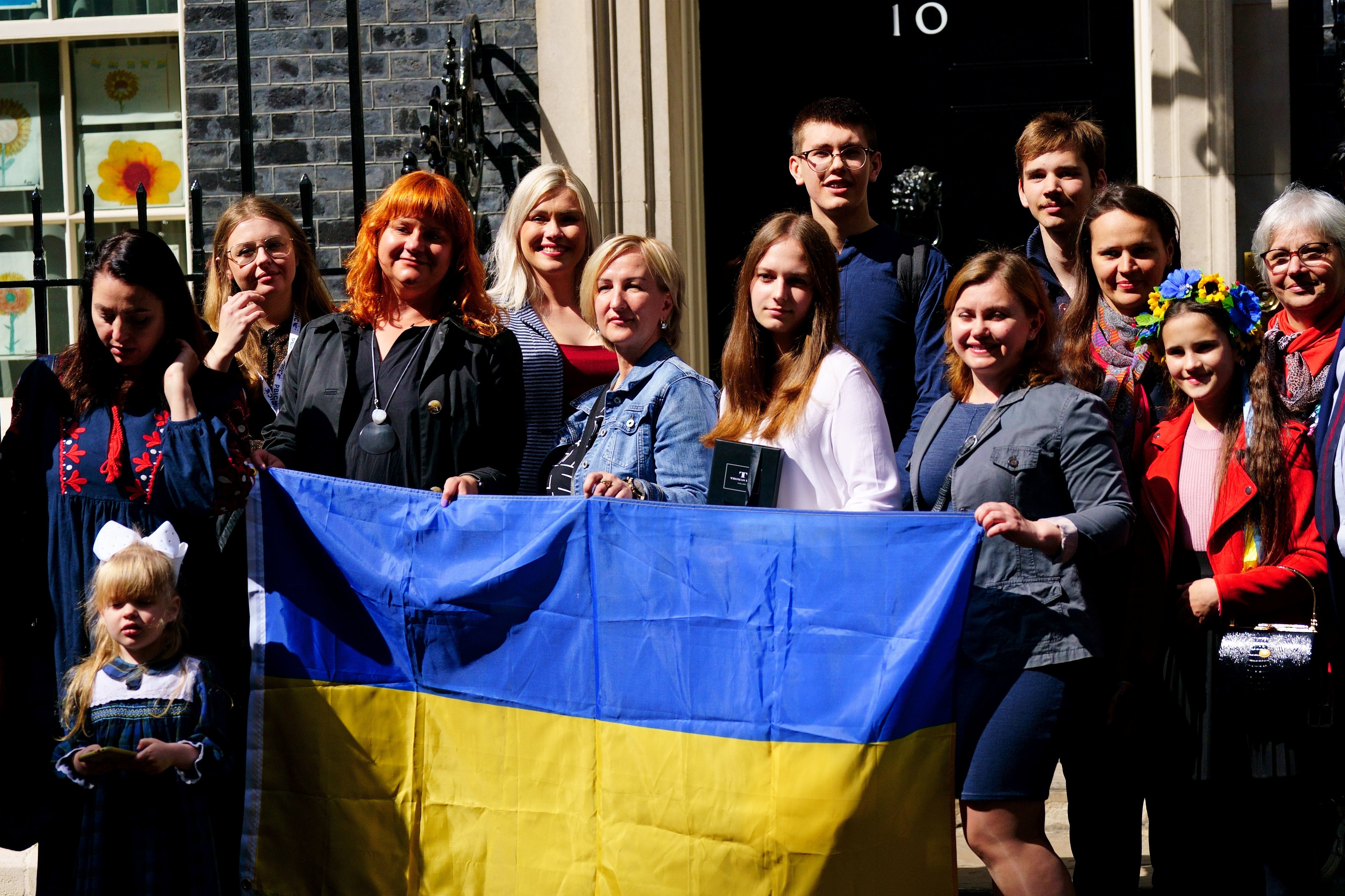 A number of Ukrainian families stand on the doorstep of 10 Downing Street after they met with the then prime minister Boris Johnson in May after arriving through the UK visa scheme