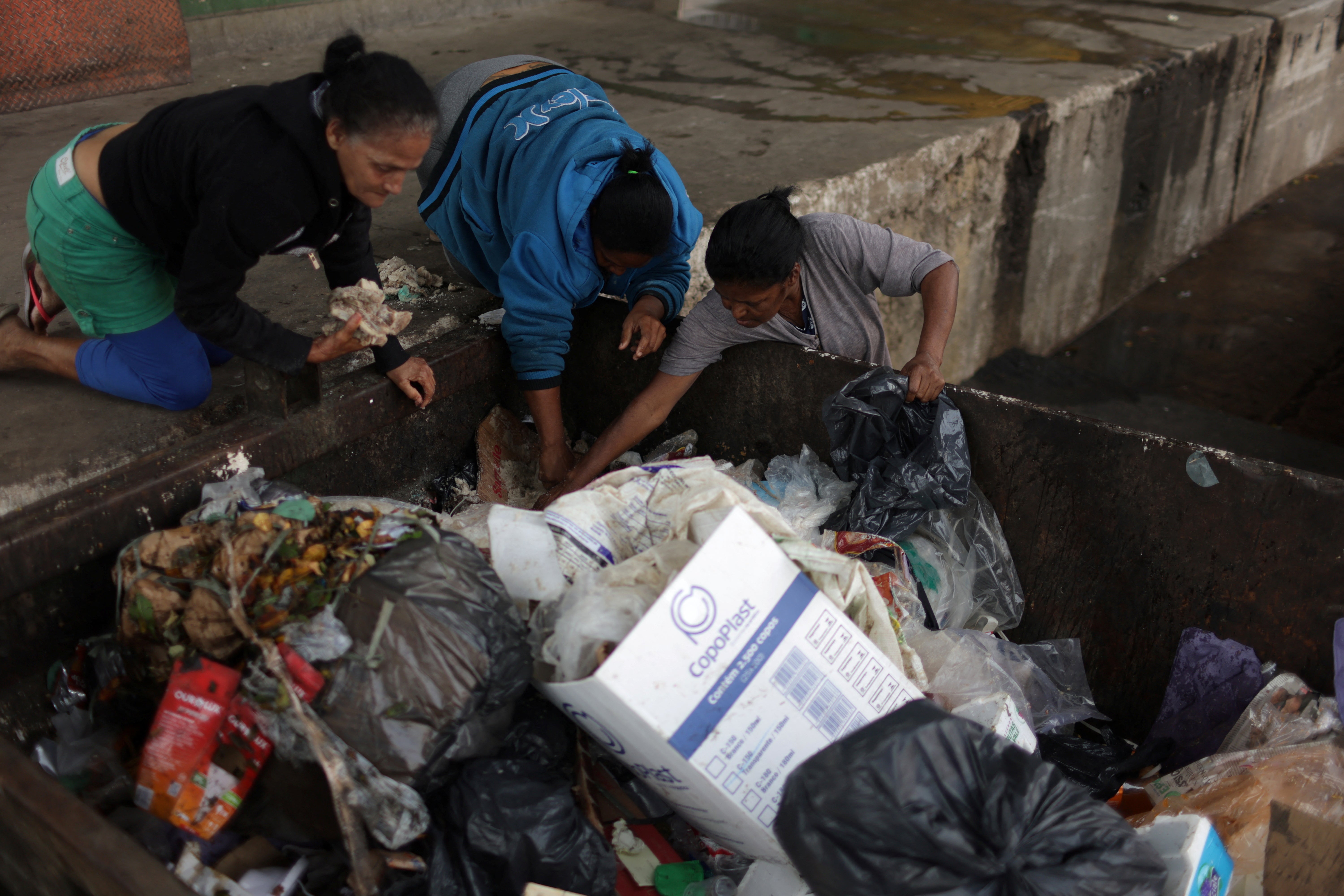 Carla sorts through food that has been thrown out to find edible products to cook