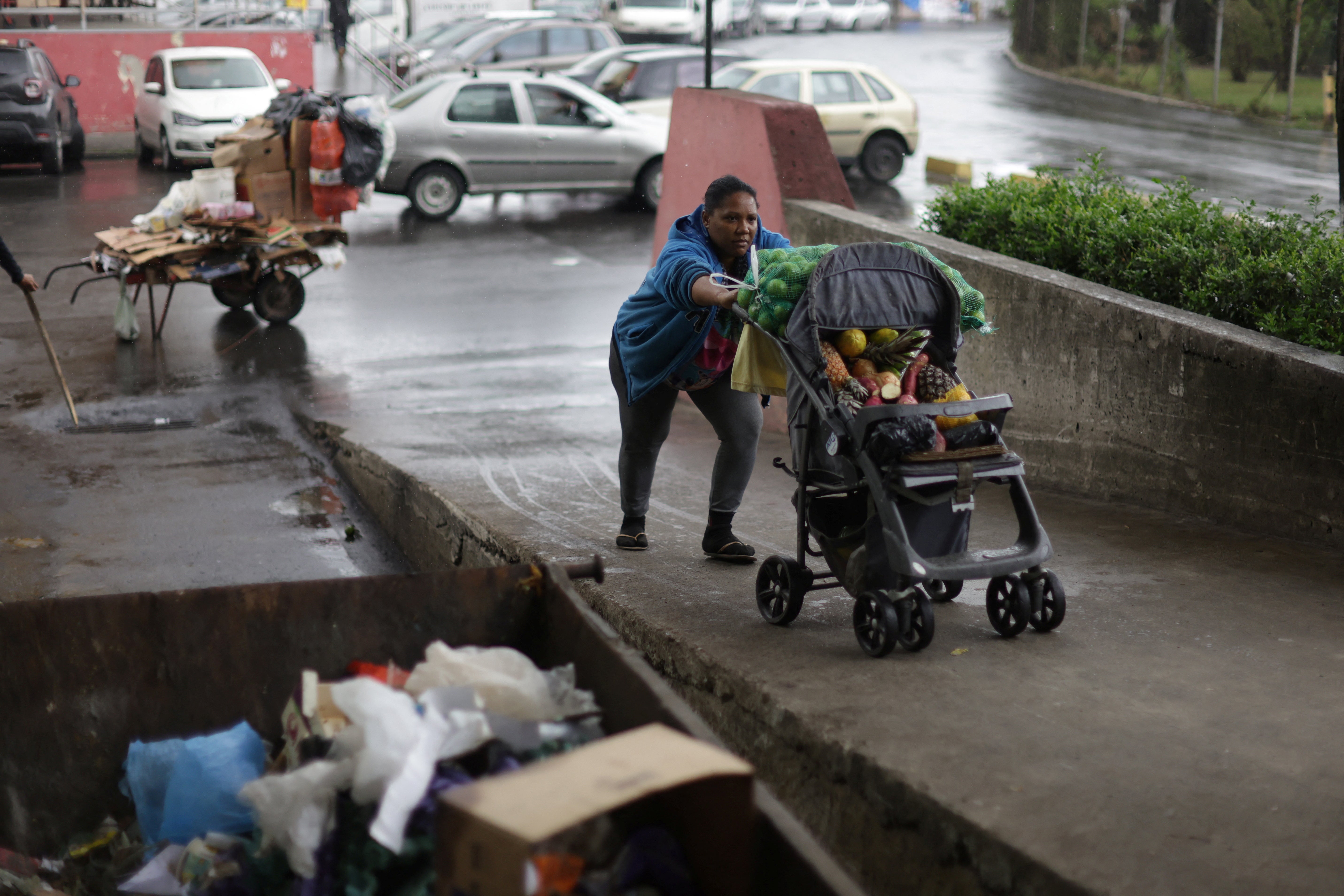 Carla dos Santos Feliciano, 38, pushes a buggy containing fruit and vegetables donated by merchants at the CEASA supply centre in Rio de Janeiro