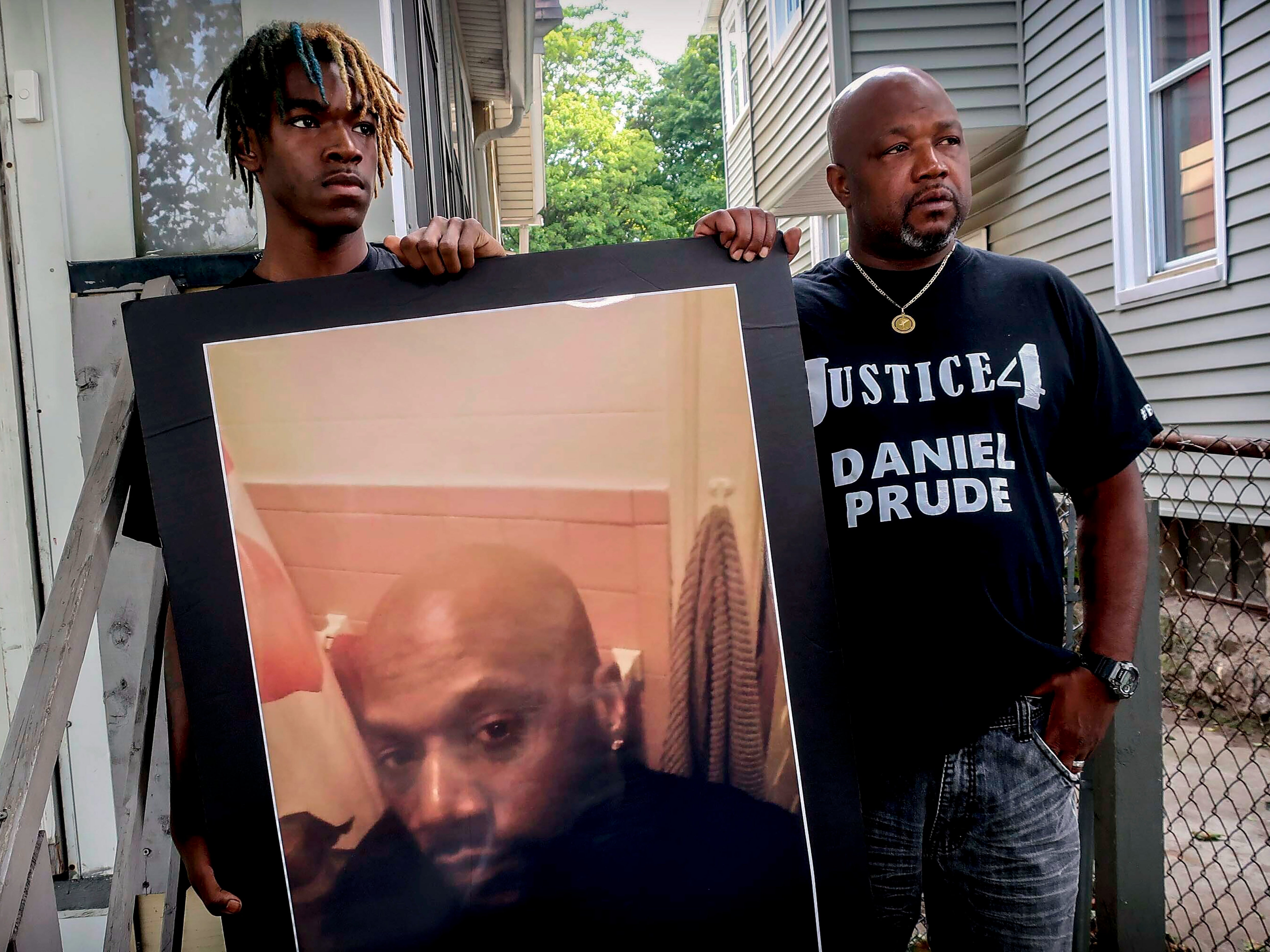 Armin Prude, left, and Joe Prude hold an enlarged photo of Daniel Prude, who died following a police encounter, in Rochester, New York