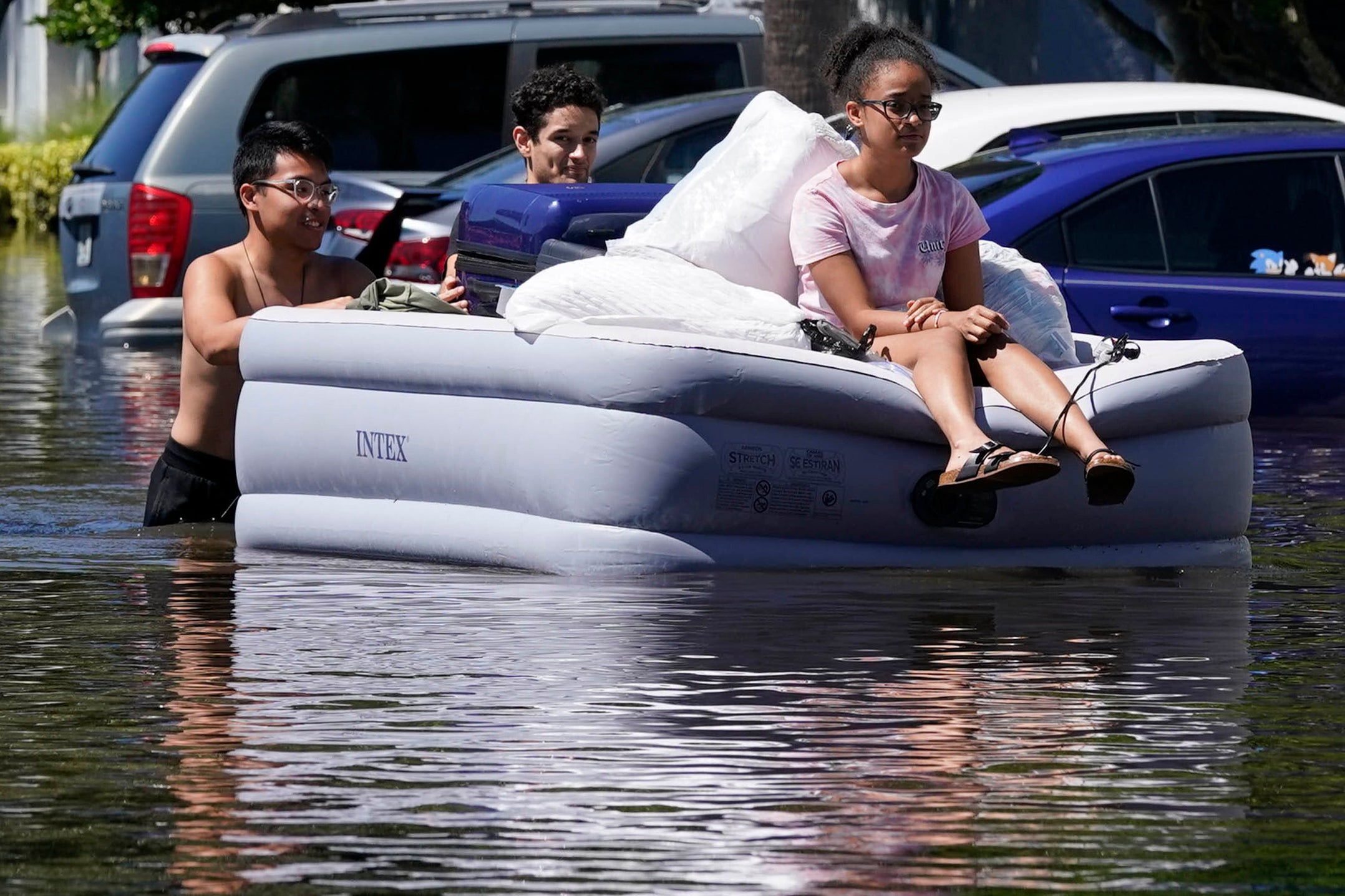 University students in Florida use an inflatable mattress to evacuate an apartment complex near the campus that was totally flooded by rain from Hurricane Ian on September 30, 2022, in Orlando (AP Photo/John Raoux)