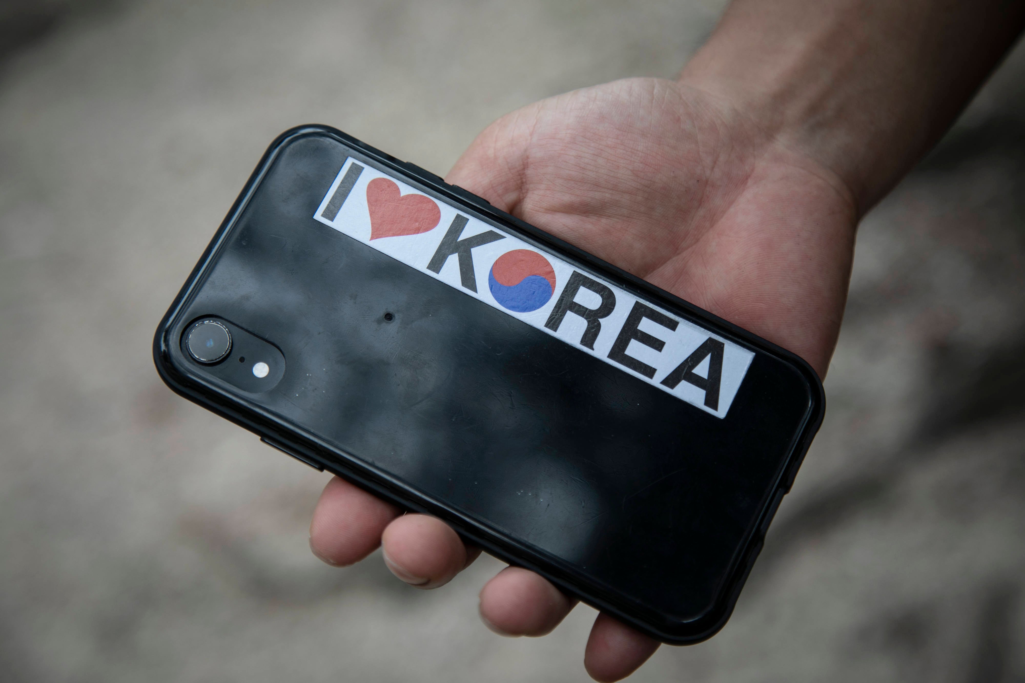 Kim Kang-woo shows the ‘I Love Korea’ sticker in the back of his phone