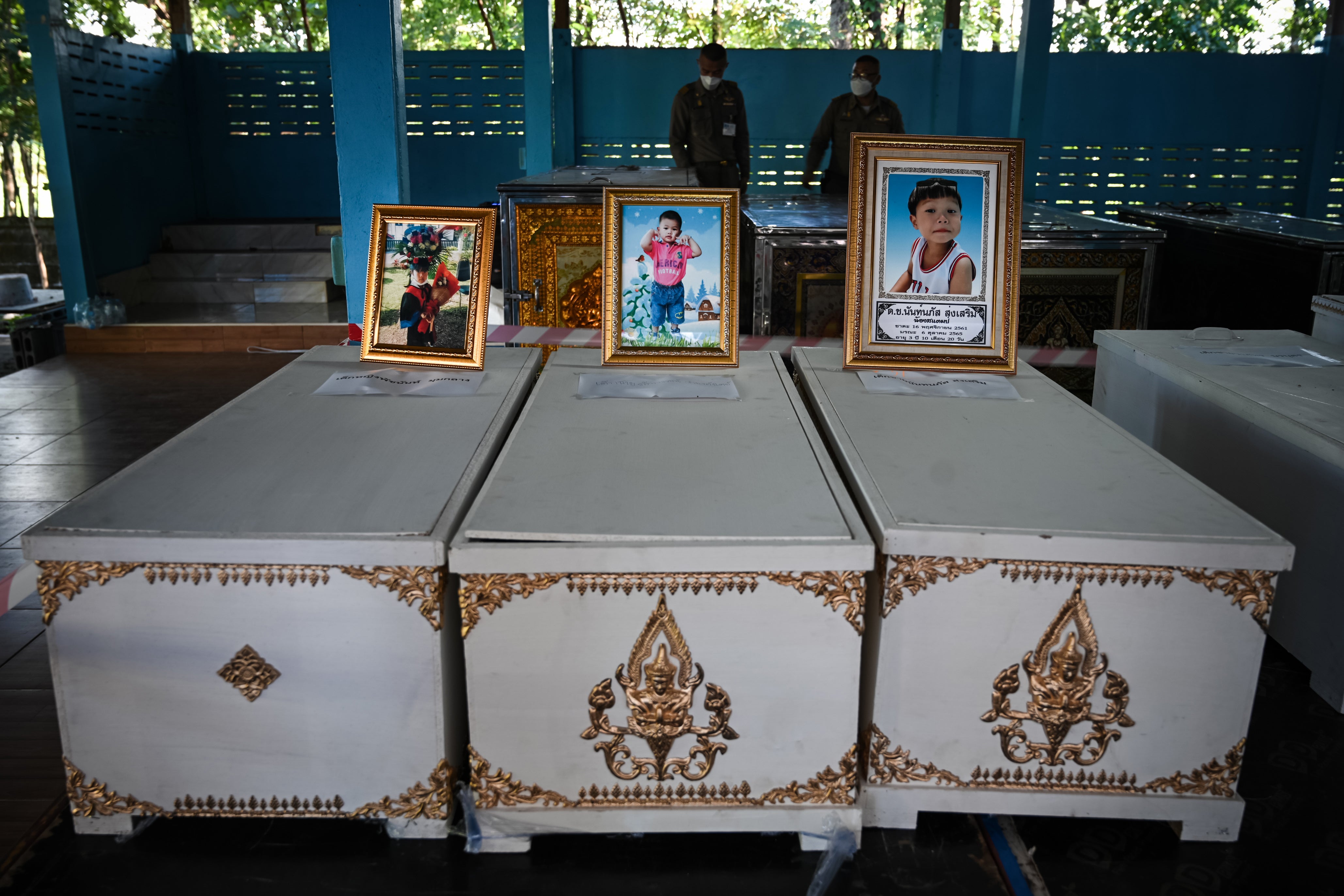 Portraits of victims sit atop coffins at Wat Si Uthai temple