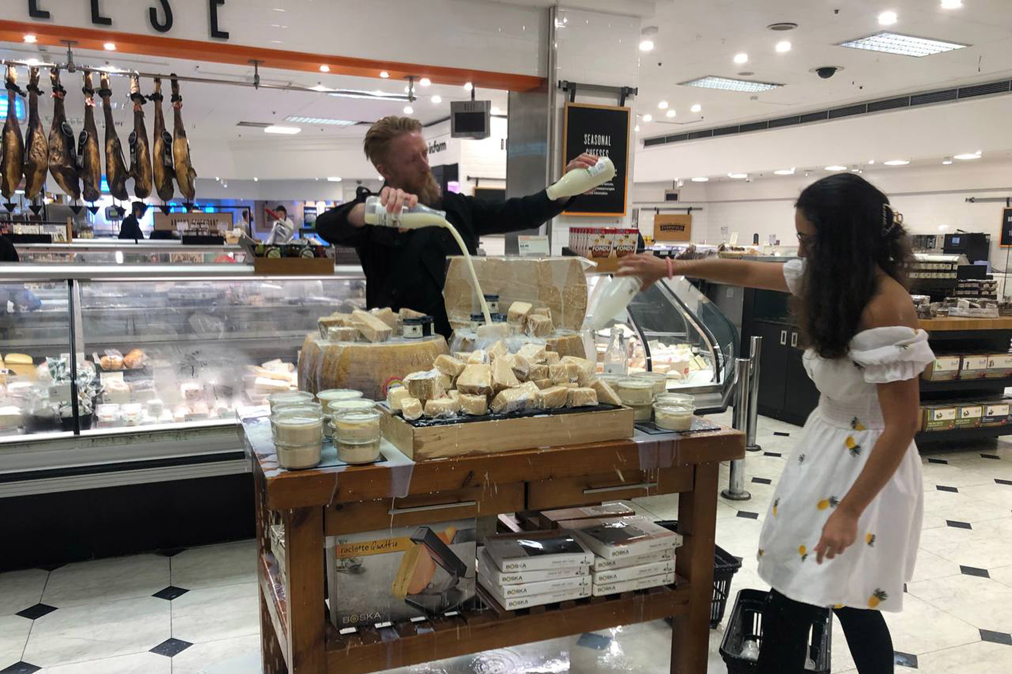 Supporters of Animal Rebellion pouring out milk in Selfridges in London (Animal Rebellion/PA)