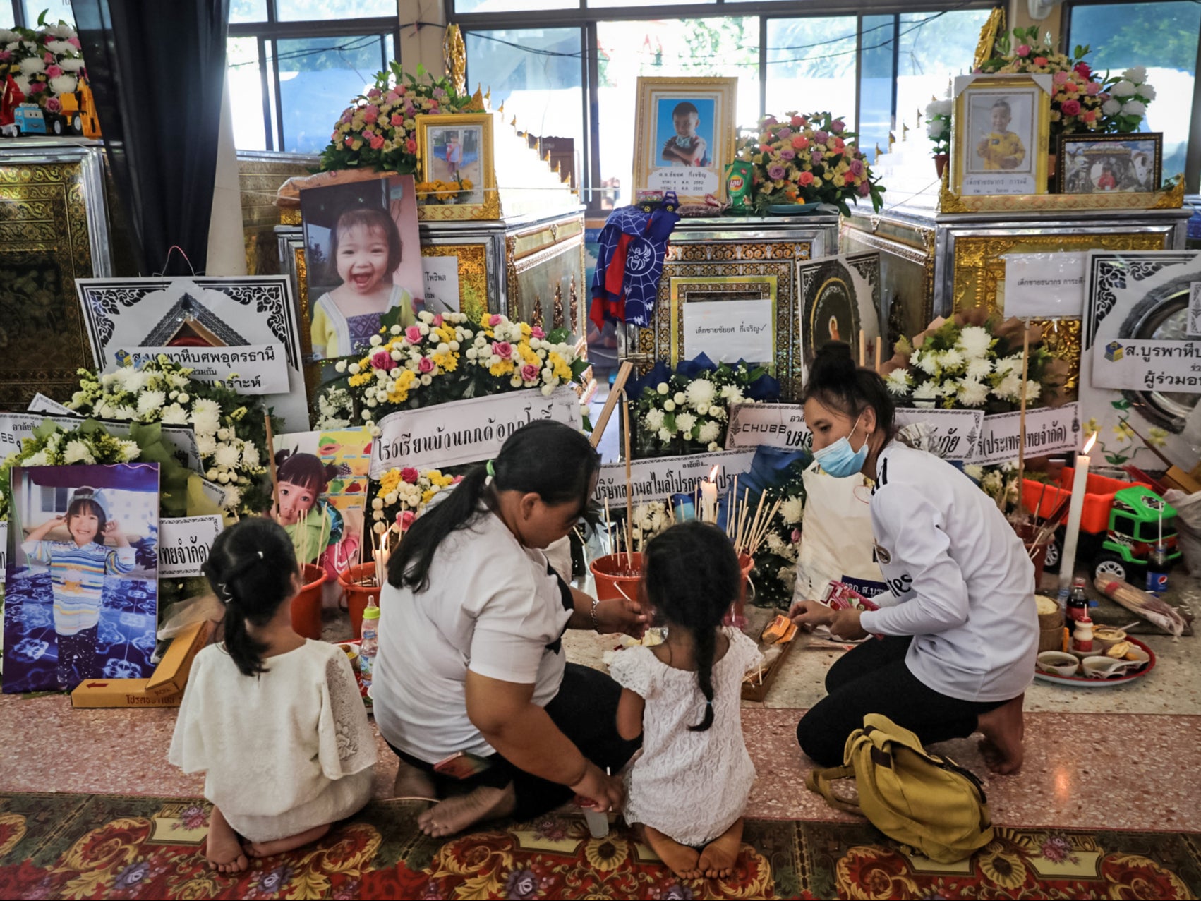 Relatives of victims gather at the Wat Rak Samakee temple