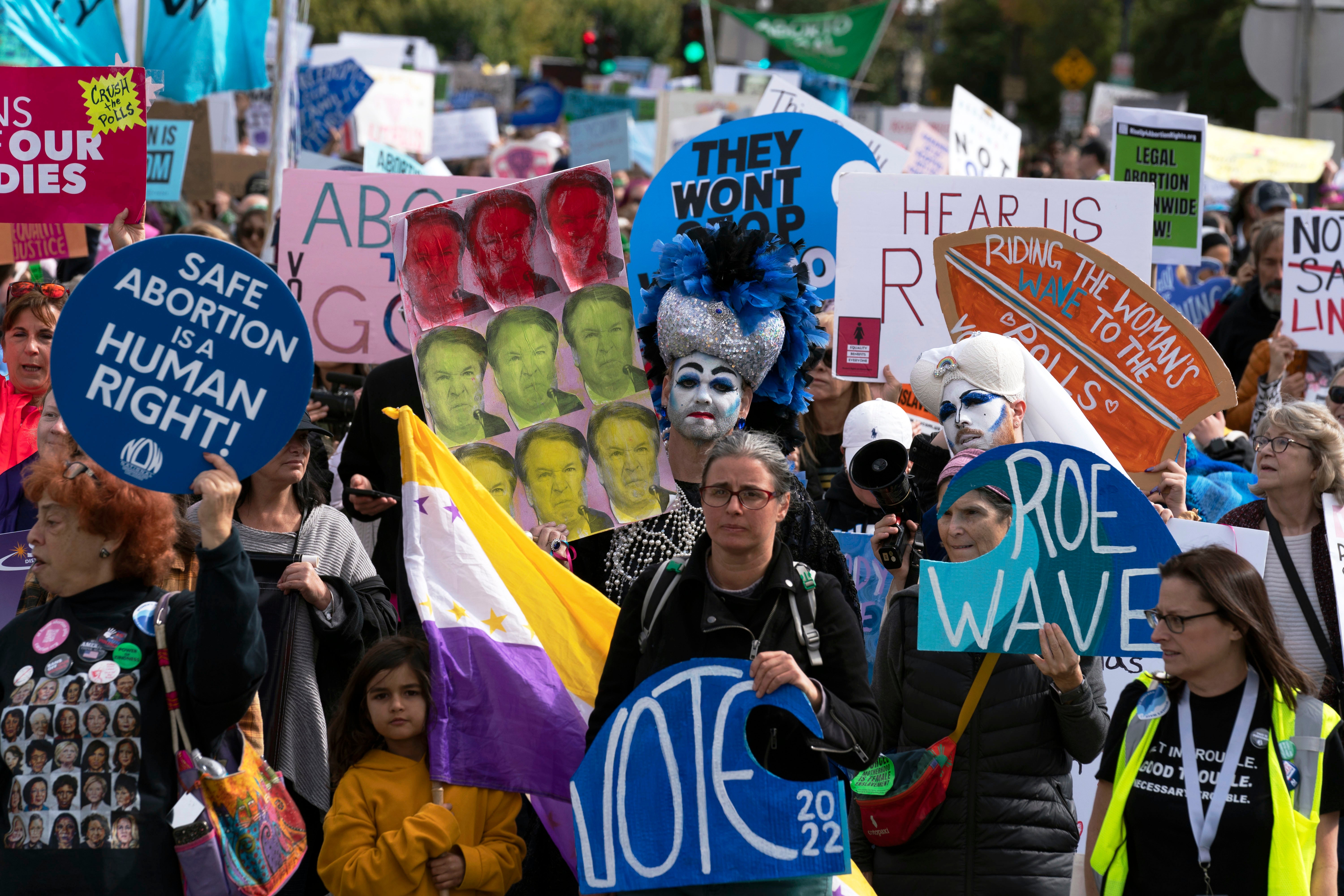 Demonstrators hold signs as they march during the Women’s March in Washington on Saturday