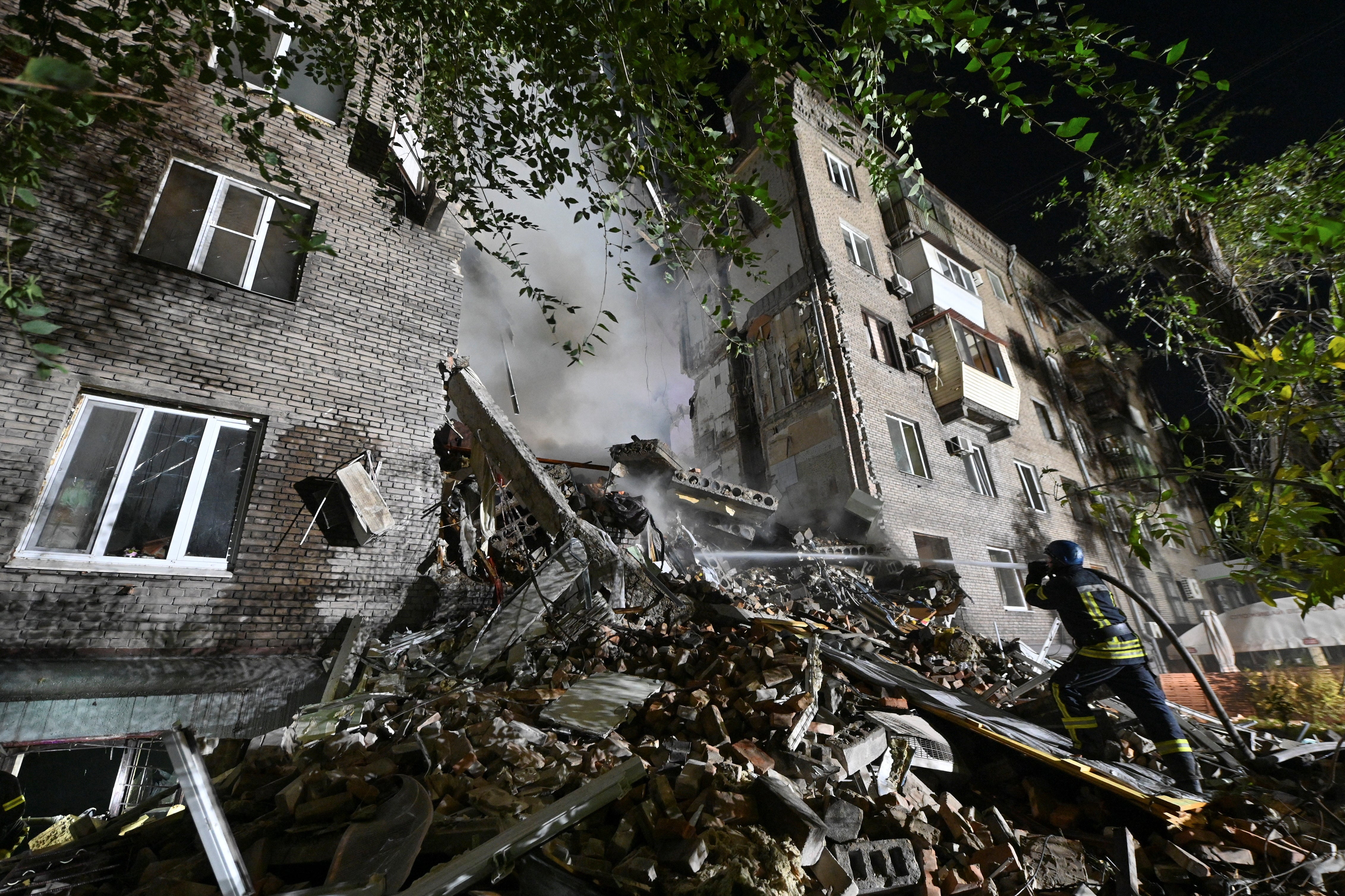 A rescuer works at a site of a residential building heavily damaged by a Russian missile strike, amid Russia's attack on Ukraine, in Zaporizhzhia