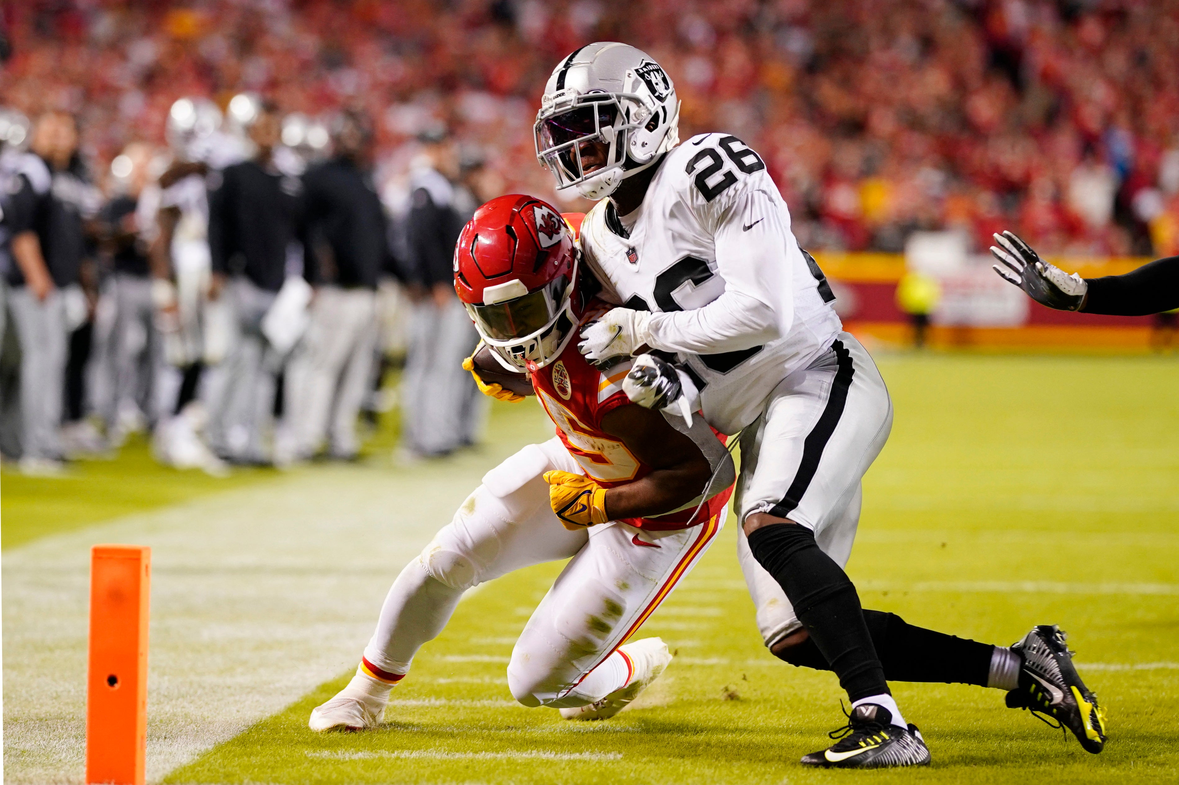 Kansas City Chiefs running back Clyde Edwards-Helaire (25) runs for the end zone pressured by Las Vegas Raiders cornerback Rock Ya-Sin (26)