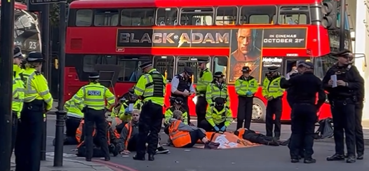 Protestors have glued themselves to the floor along a busy Knightsbridge road