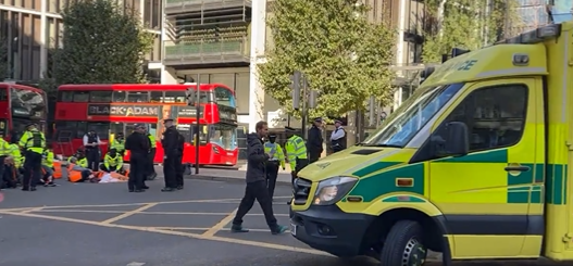 An ambulance tries to find a way through the protest this morning