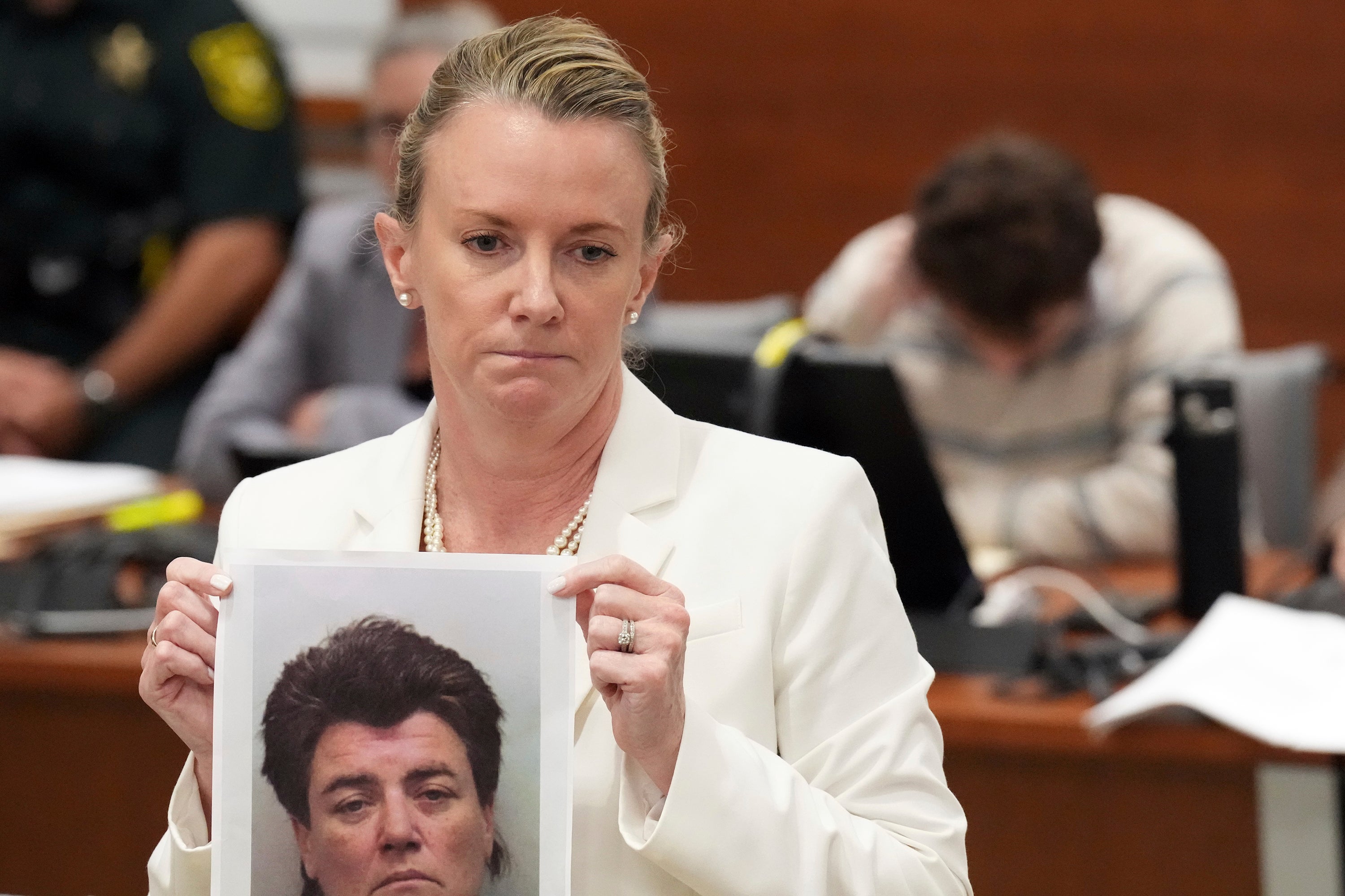 Melisa McNeill holds up a photo of Cruz’s biological mother Brenda Woodard