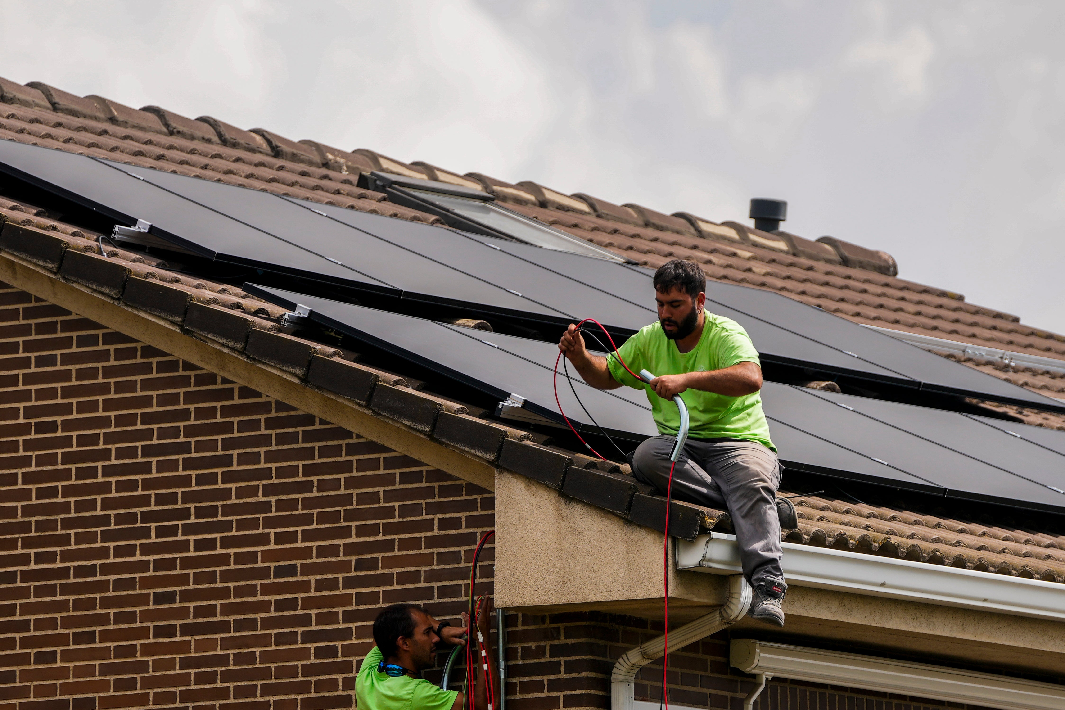 Workers install solar panels on the roof of a house in Rivas Vaciamadrid, Spain