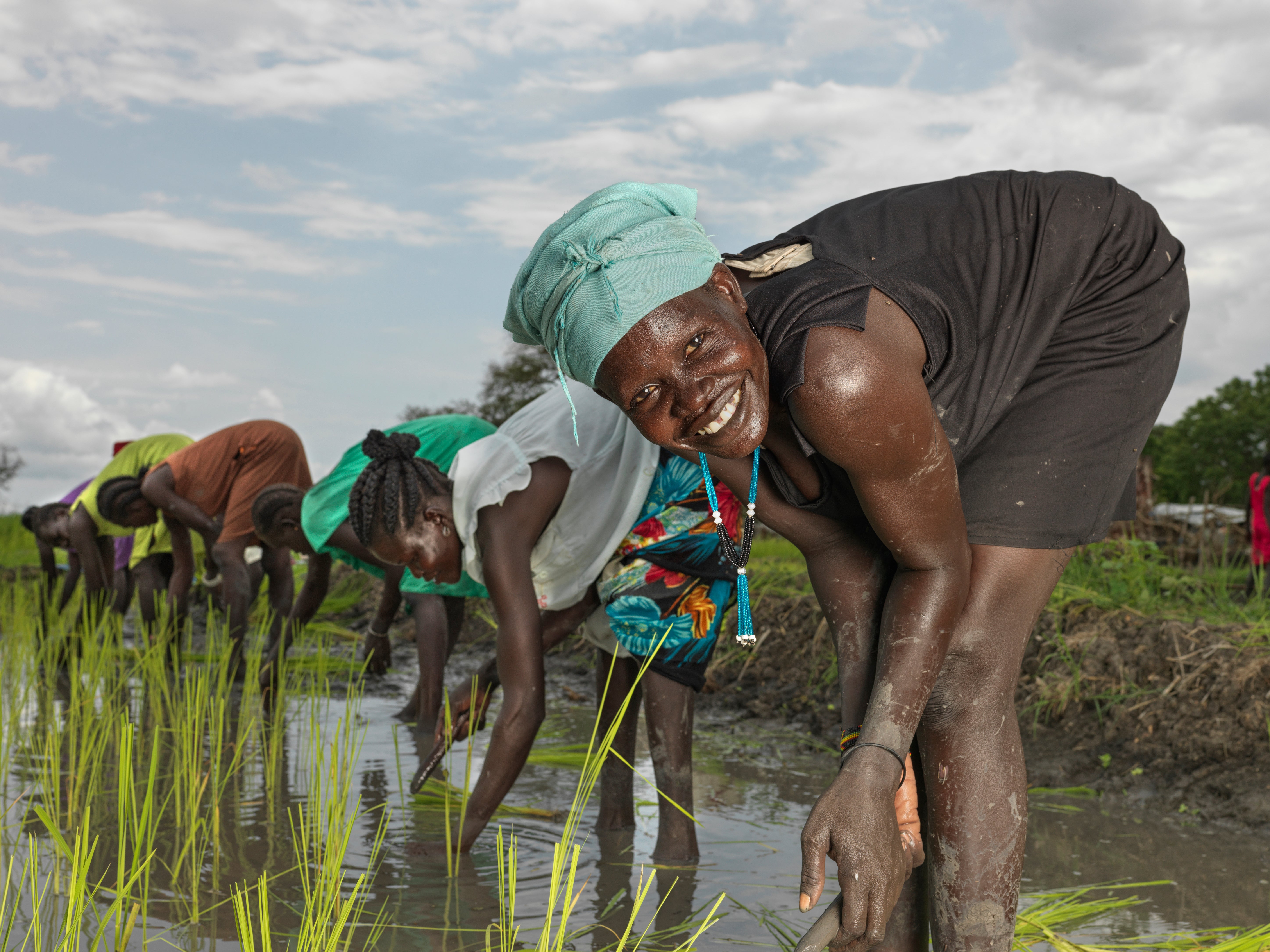 Nyamokah Duoth, 26, plants rice at the Action Against Hunger rice paddy in Paguir