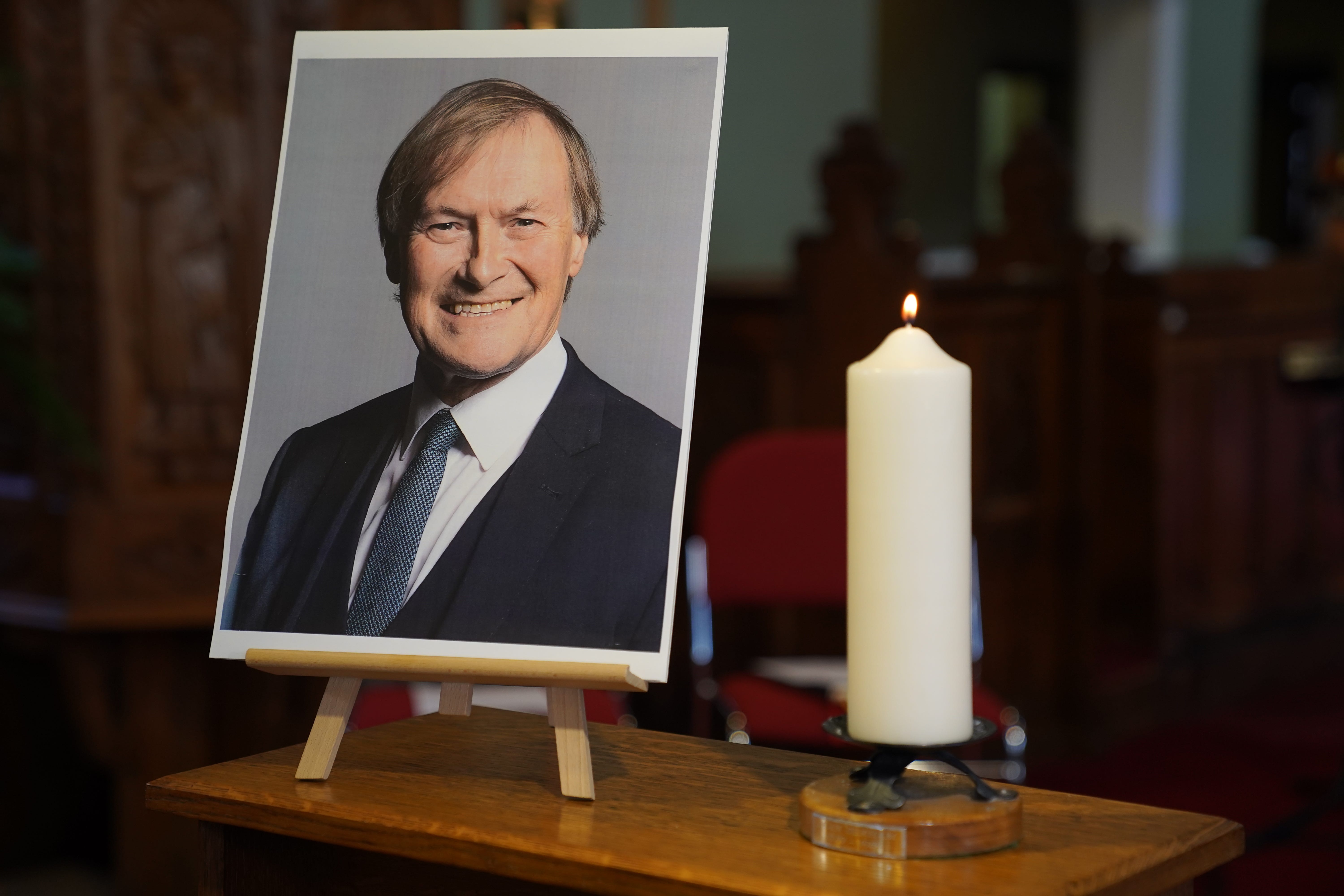 A candle and a photo at a vigil in Leigh-on-Sea, Essex for David Amess